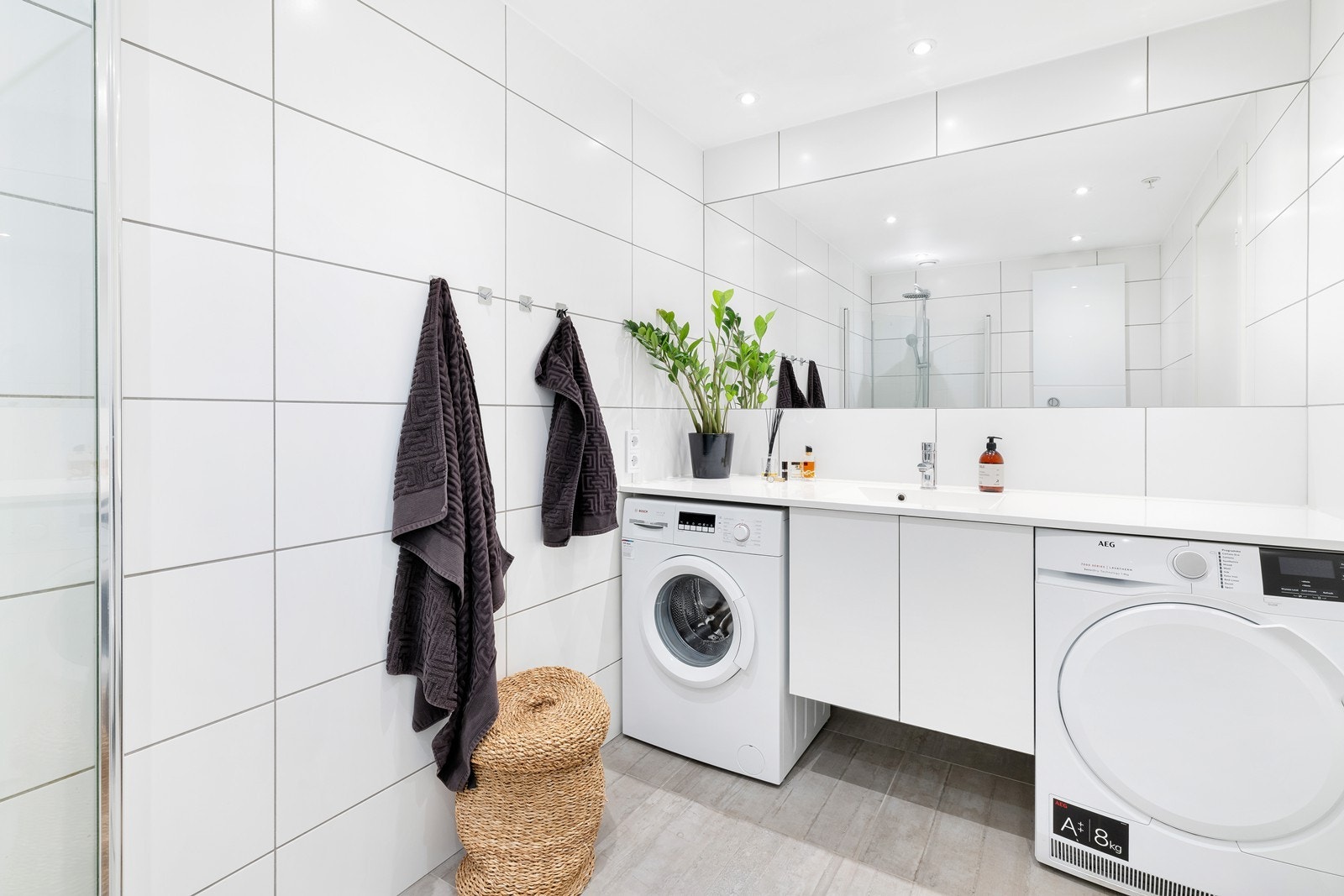 Leilighetens baderom har en fin og moderne standard og inneholder dusjhjørne, servant og wc. Videre er det opplegg for vaskemaskin. Galleribilde