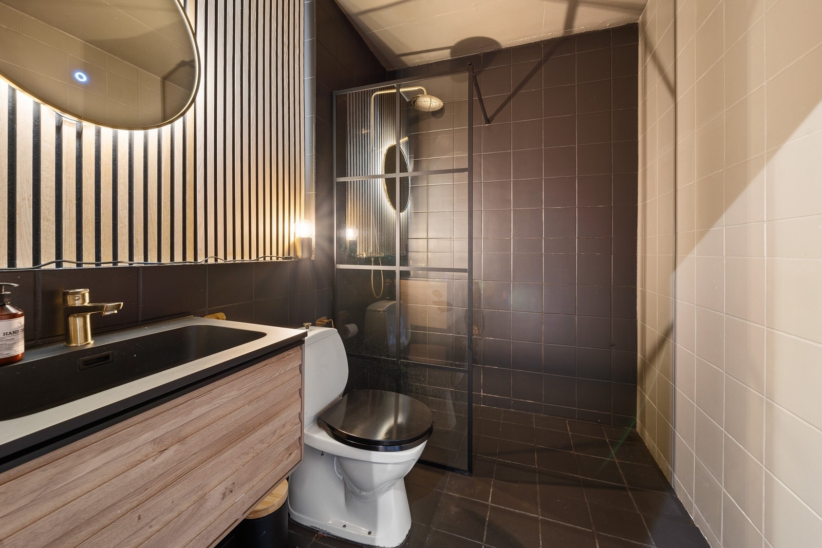 Badet har servant med skuffer under, wc og dusjhjørne. Galleribilde
