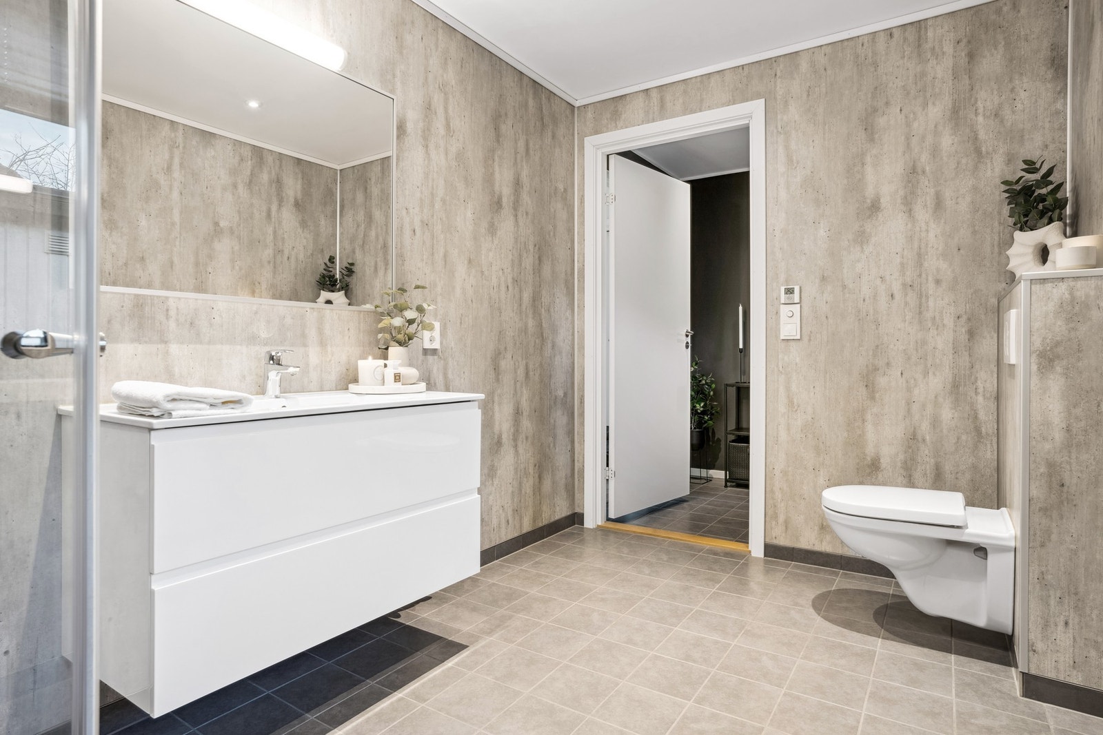 Badet er utstyrt med baderomsinnredning, dusjplass og veggmontert toalett Galleribilde