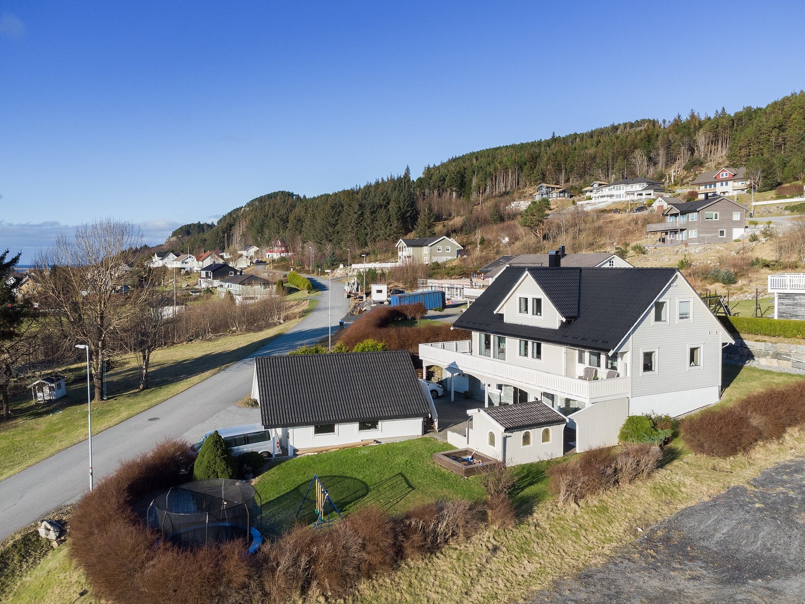 Velkommen til Fjellheim 48. Tomten er pent beplantet med hekk, prydbusker og med støttemur mot nord. Fasadebilde med utsikt mot vest. Galleribilde