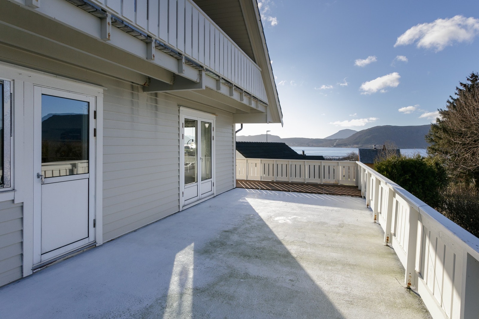 Veranda og luftebalkong på vestsiden. Den enkle verandadøren er til soverom og tofløyet verandadør til stue. Skjermet og romslig plass når ettermiddagssola kommer. Galleribilde