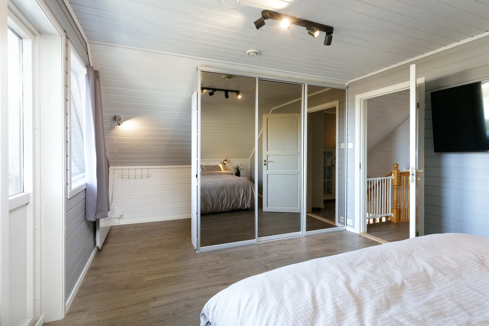 Romslig soverom i loftsetasjen, utgang til luftebalkong, stor skyvedørsgarderobe med speilfronter. Det er i tillegg smart oppbevaringsplass bak garderoben. Galleribilde