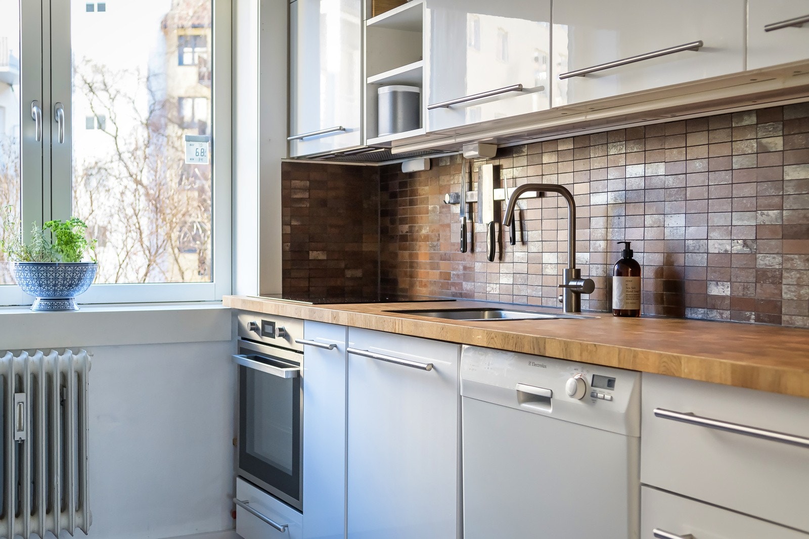 Praktiske fliser i benkerygg og belysning under overskap. Galleribilde