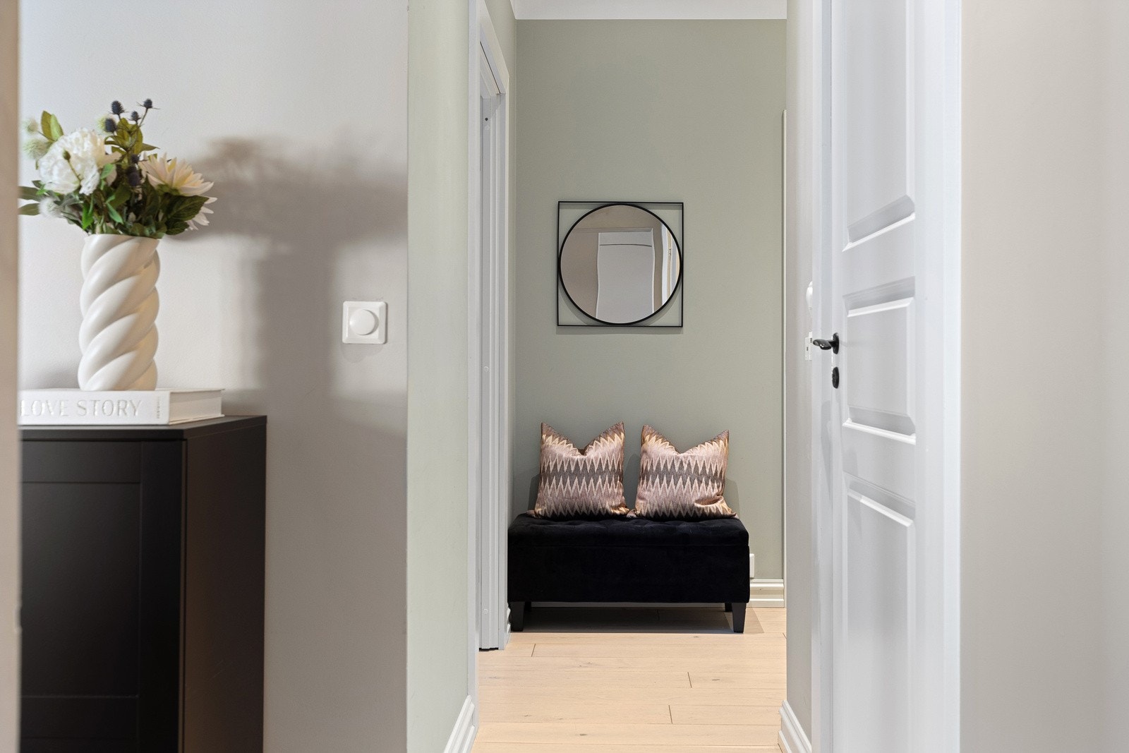 Hyggelig entré med lyse vegger og gulv, samt spotlights i taket Galleribilde