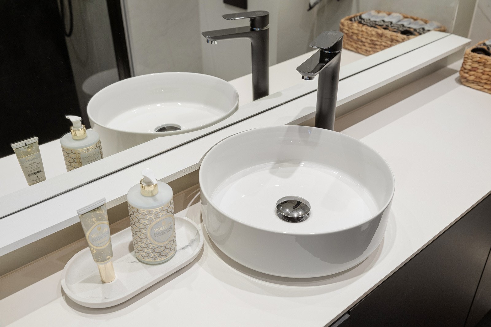 Rommet er utstyrt med en stilren servantinnredning med servantbolle, vegghengt toalett og et dusjhjørne med regnfallsdusj og innfellbare dører Galleribilde