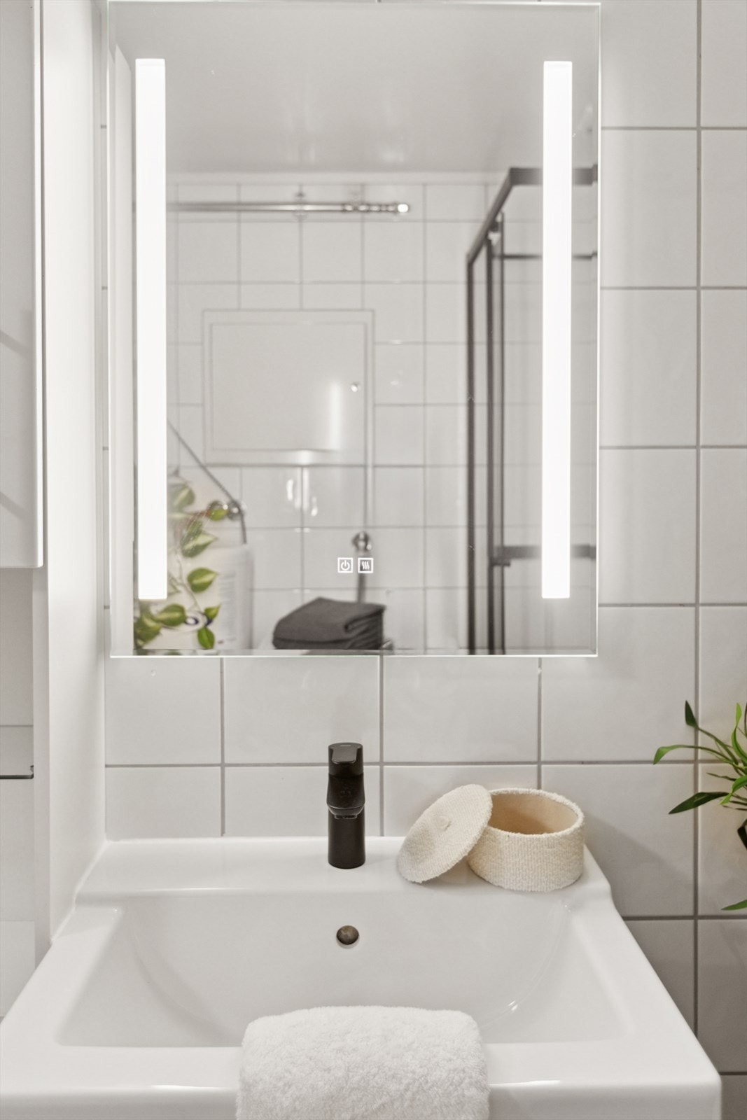 Baderommet er flislagt og innredet med nøytrale farger som gjør det enkelt å supplere med dekor av egen stil og smak. Galleribilde