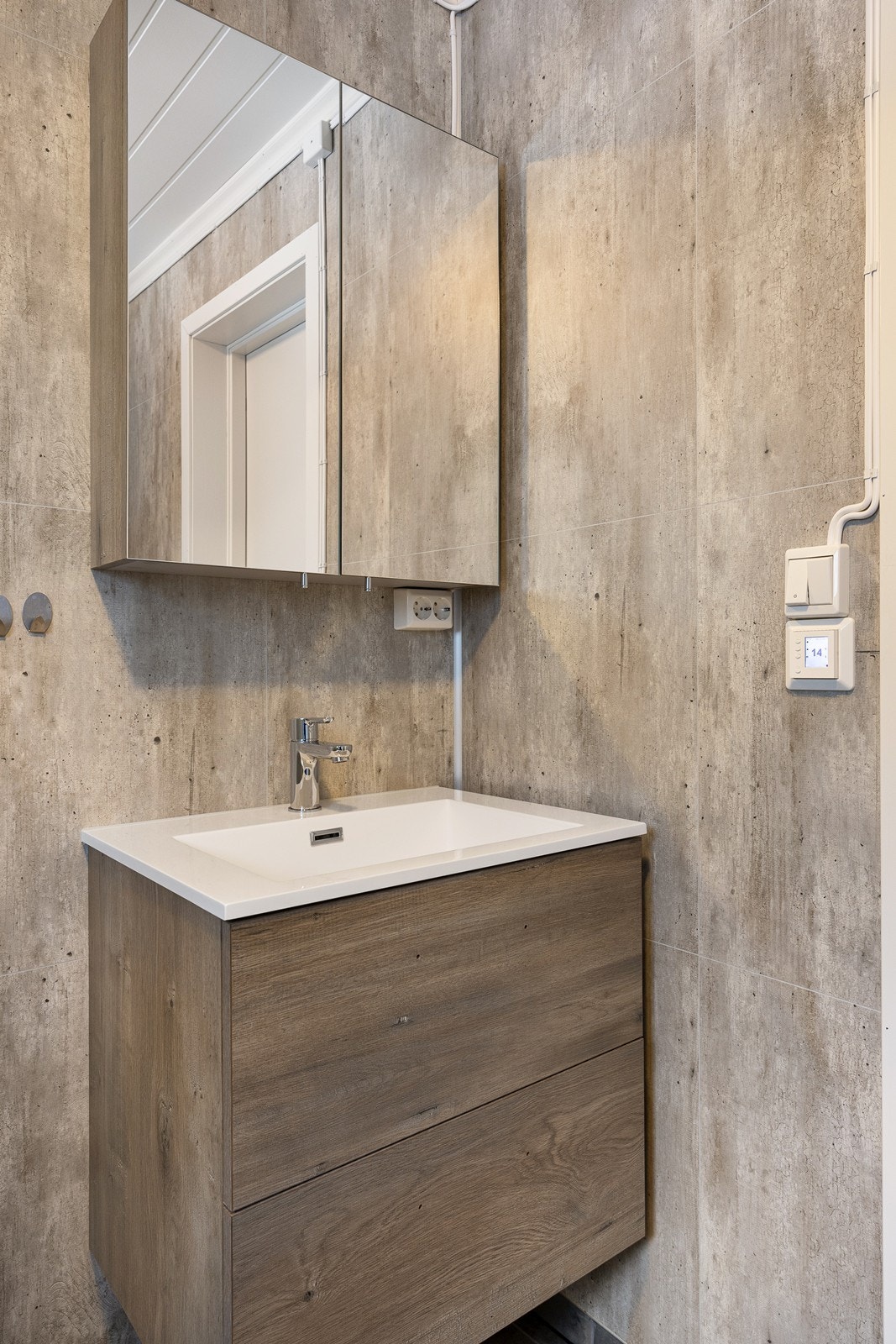 Innredningen har heldekkende servant over skuffeseksjon og et matchende speilskap. Galleribilde