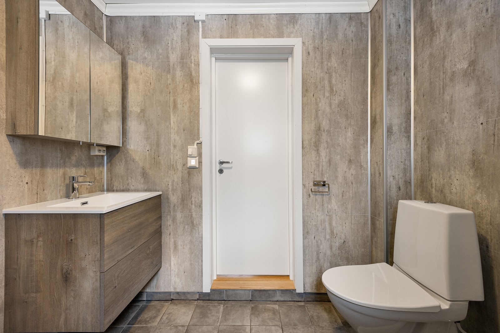 Videre er toalettet gulvmontert, dusjhjørnet har innfellbare dører og det er opplegg for vaskemaskin. Galleribilde