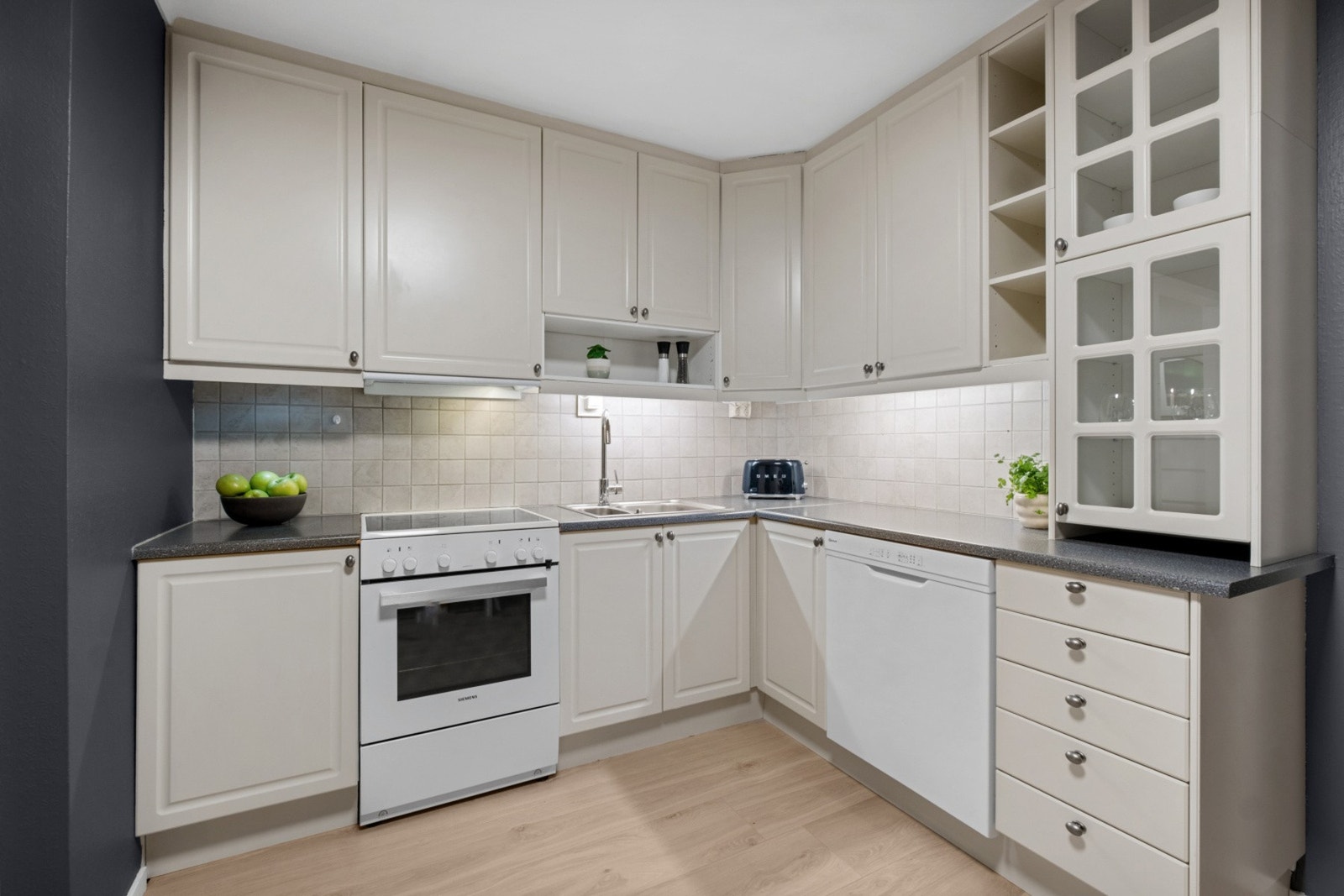 Kremfarget profilerte fronter, utbygget med takhøye
overskap og benkeskap. Galleribilde