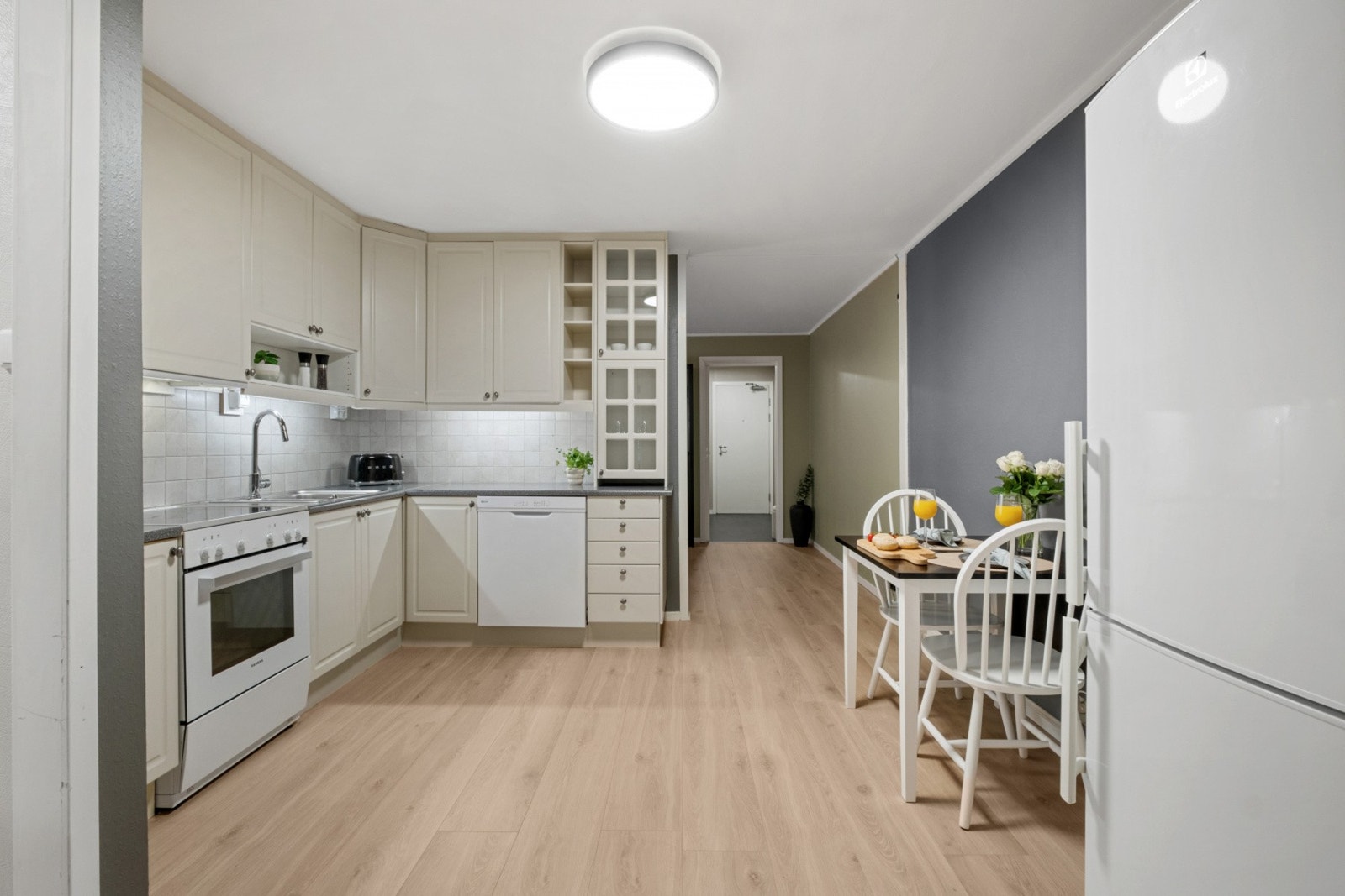 Innredning med
vinklet spettet laminat benkeplate, nedfelt vaskebenkbeslag. Fliser
over benk. Galleribilde