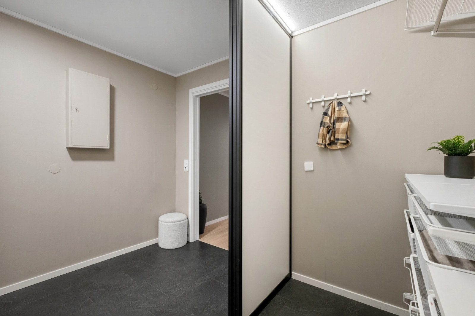 Leiligheten har en pen entré med klikklaminat på gulvet og lysmalte panelplater på veggene. Galleribilde