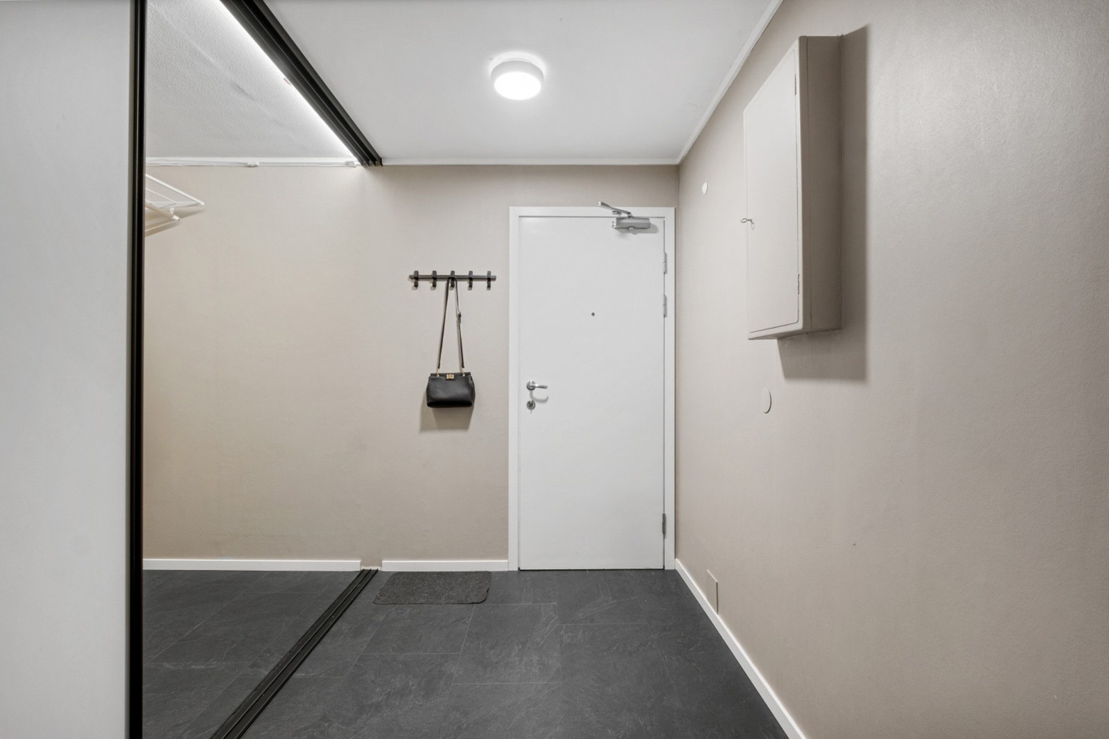 En takhøy skyvedørsgarderobe med speilfronter har god nok dybde til at man kan gå inn i den - her er det god plass til yttertøy, sko og annet utstyr. Galleribilde