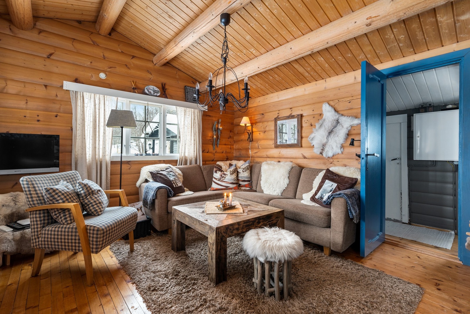 Hytta byr på ei hyggelig stue med god takhøyde og gjennomgående panel i tak og vegg. Galleribilde