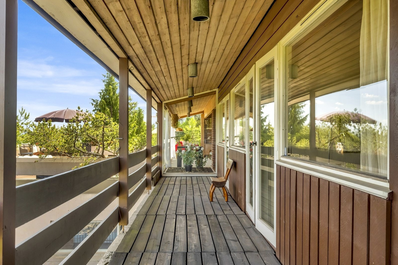 Balkongen går langs hele husveggen og er overbygget. Legg merke til hvordan vinduet mot stuen går fra gulv til tak og slipper inn god med lys til stue og trappeløpet. Galleribilde