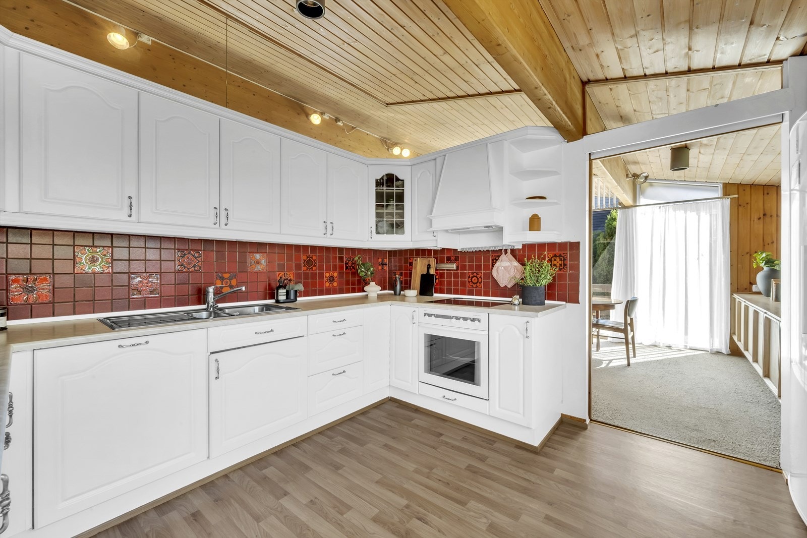 Klassisk kjøkken med profilerte fronter. Kjøkkenet fra 2003 med integrerte hvitevarer og kullfiltervifte over kokeplate. Galleribilde