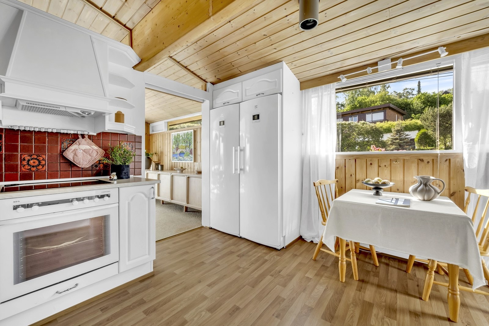 Frittstående kjøleskap og fryseskap i egen nisje (kjøl- og fryseskap medfølger). Hyggelig frokostplass på kjøkkenet ved vinduet. Galleribilde