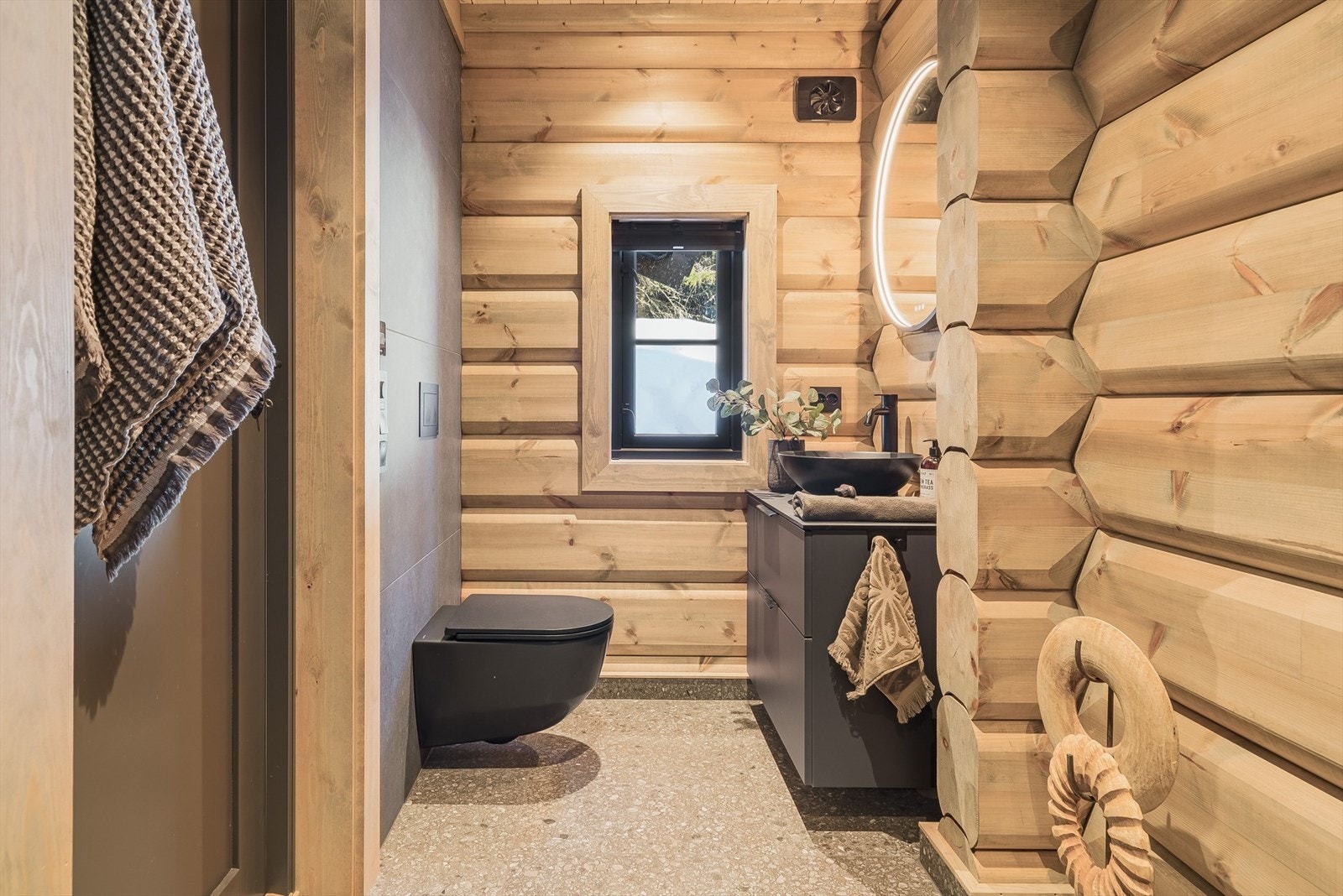 Det tredje og siste badet ligger i tilknytning til entréen på hytta. Badet er i likhet med de andre badene pent innredet med røffe fliser på gulv som passer godt til hytten, delvis tømmer og fliser på veggflatene. Galleribilde