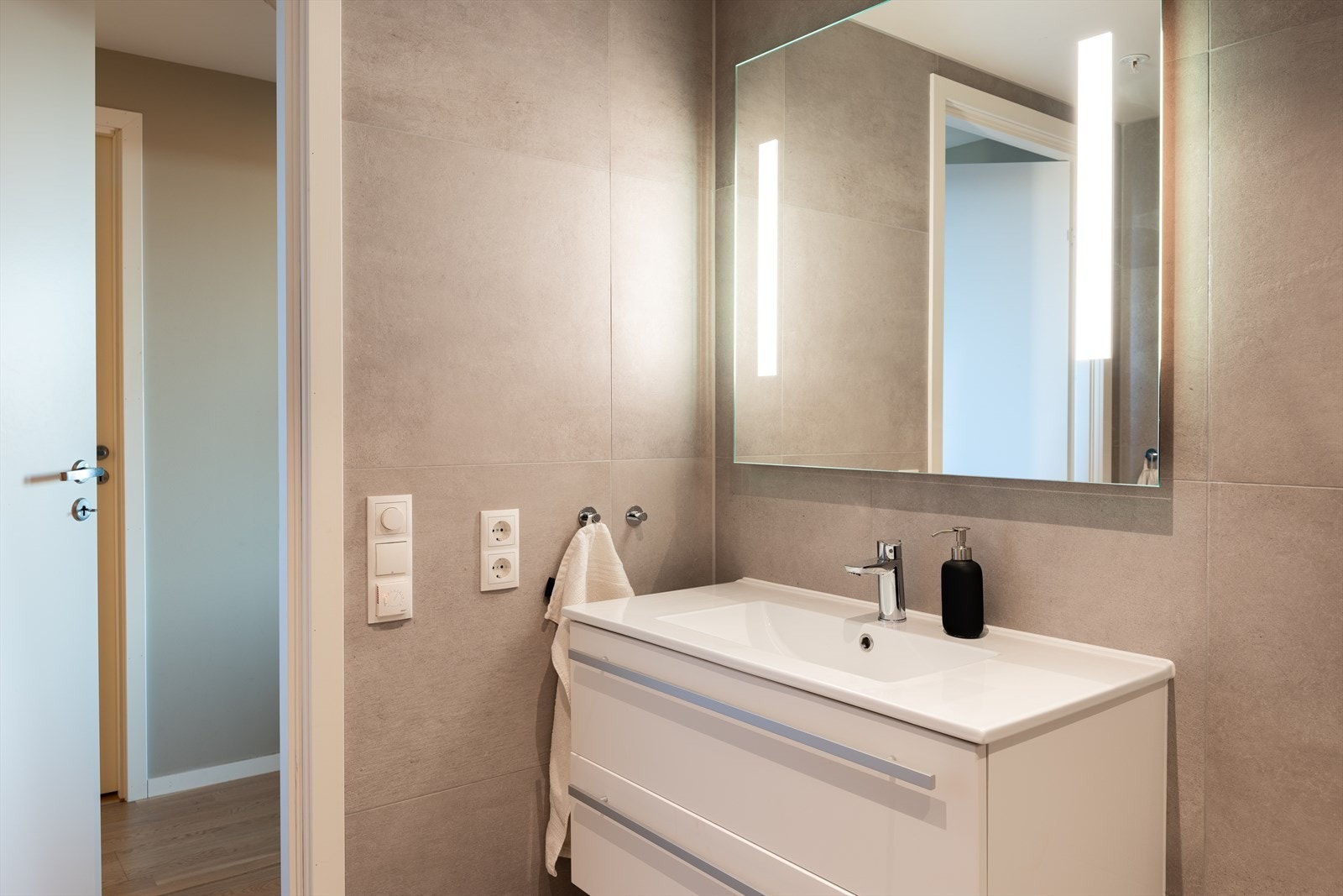 Det er gjort tilvalg med 60x60 fliser i beige grå farge på både vegg og gulv. Badet er i likhet med resten av leiligheten vurdert til tilstandsgrad 0. Galleribilde