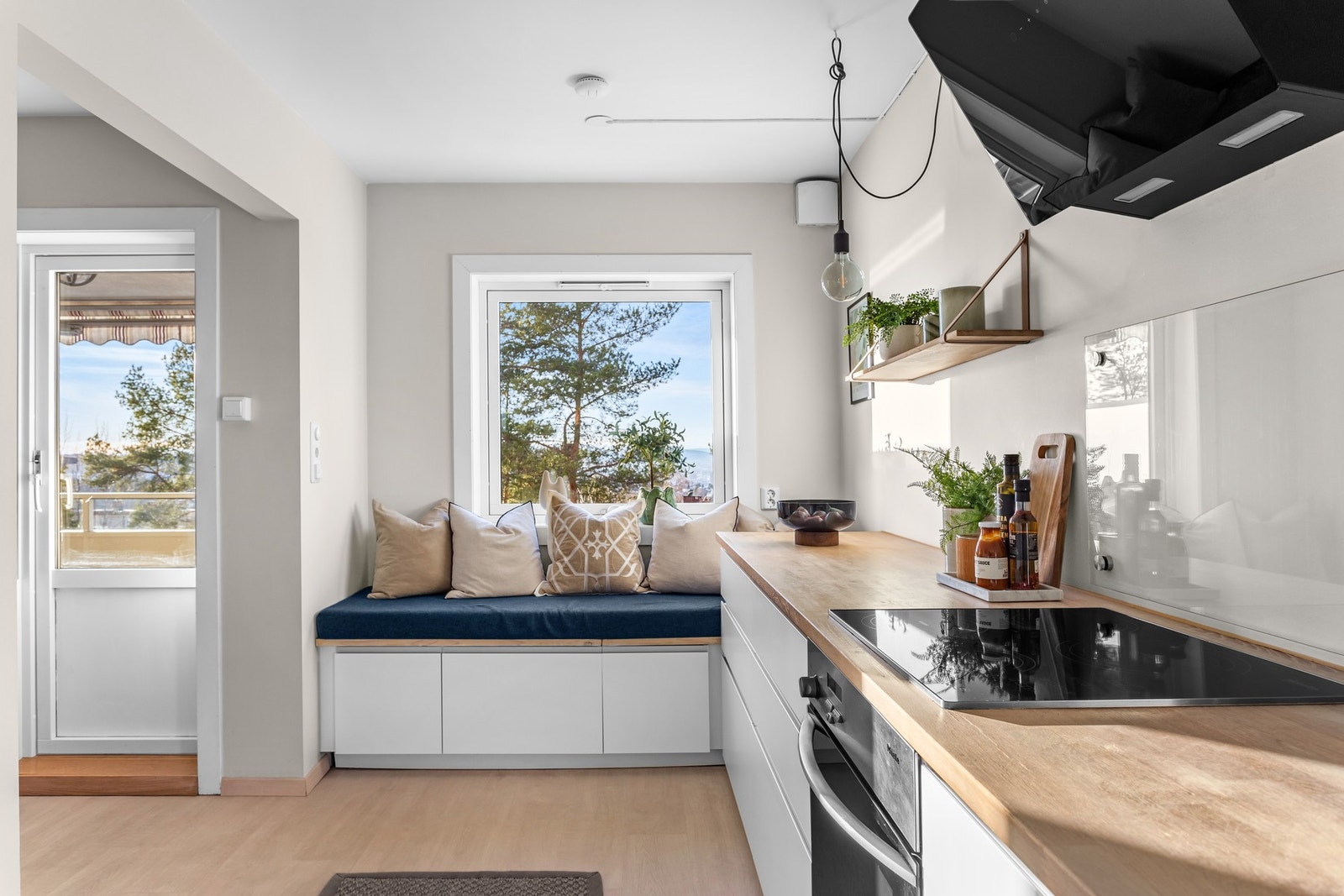 Ved vinduet på kjøkkenet er det en hyggelig sittebenk med oppbevaring under Galleribilde