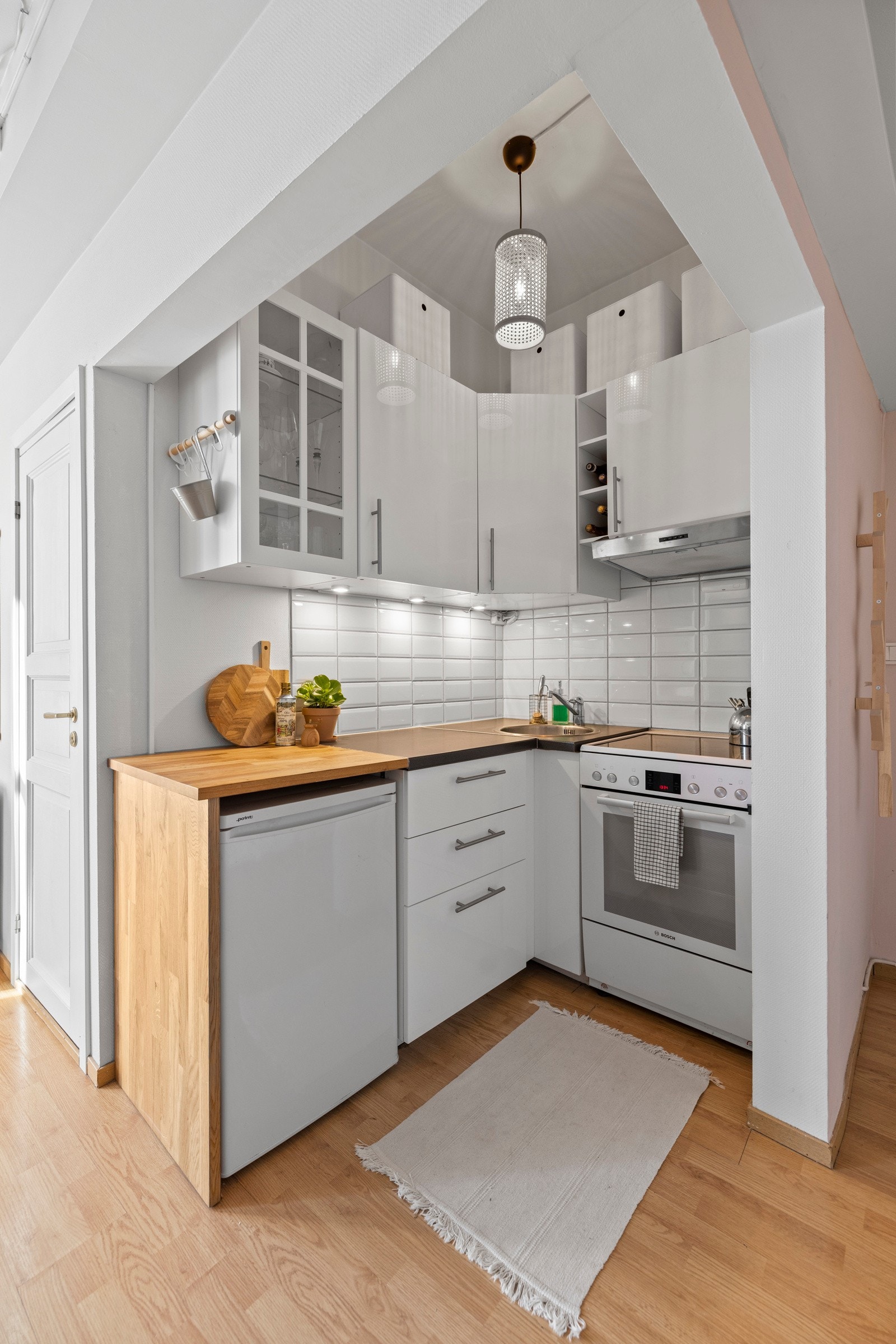 - Kjøkkeninnredning med glatte fronter. Enkelte glassfronter i overskap. Belysning under overskap. Fliser på vegg over benkeskap. Laminat benkeplate, samt en del med heltre benkeplate - Galleribilde