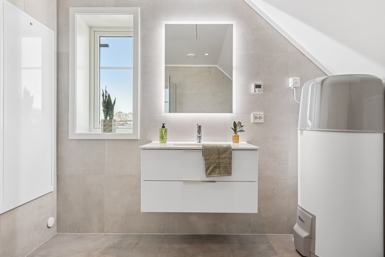 Badet er innredet med lyse og moderne fargevalg på fliser og interiør. Galleribilde