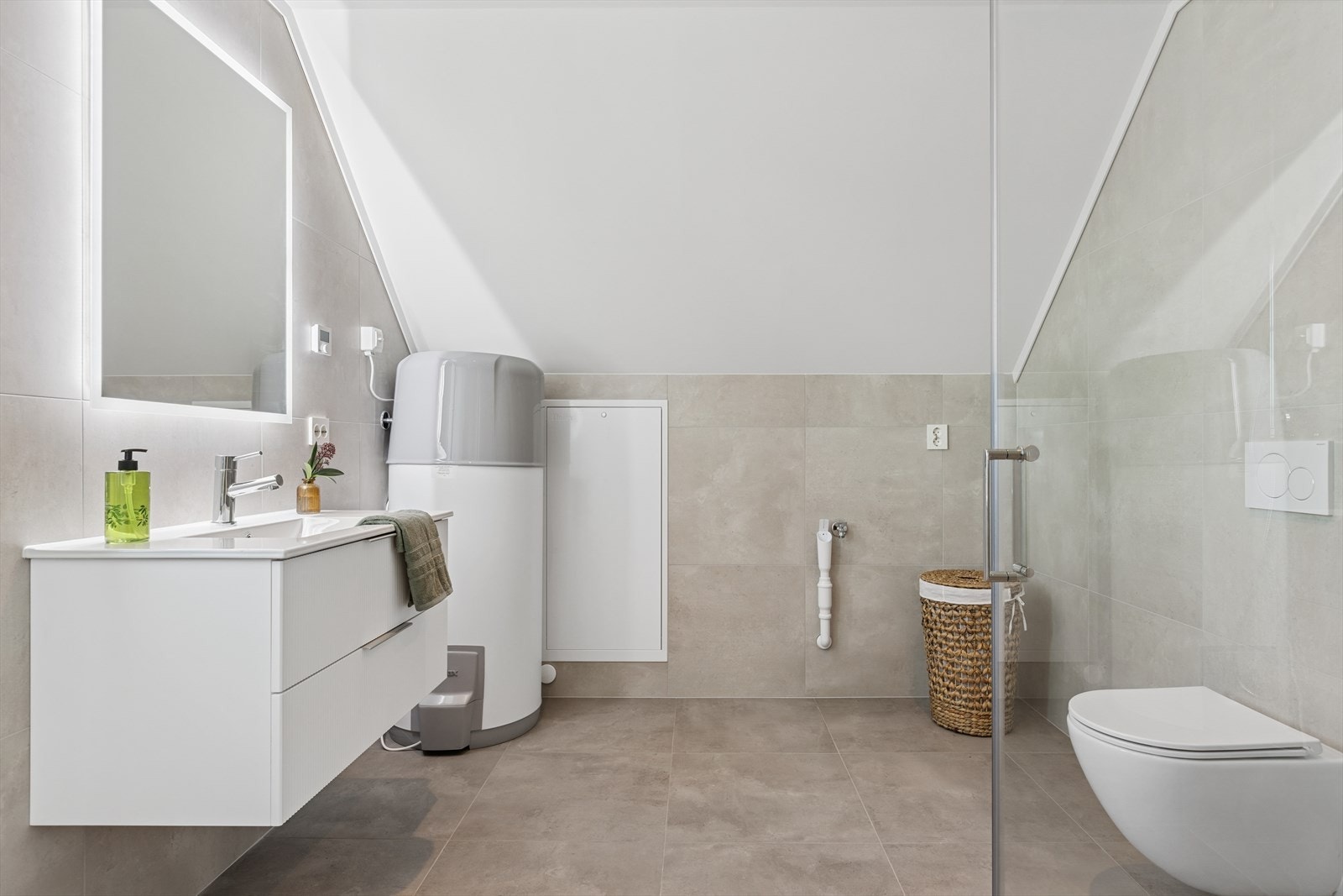 Badet er innredet med vegghengt klosett, servant på innredning og dusjhjørne med svingbare dører. Opplegg for vaskemaskin. Balansert ventilasjon. Vannbåren varme. Galleribilde