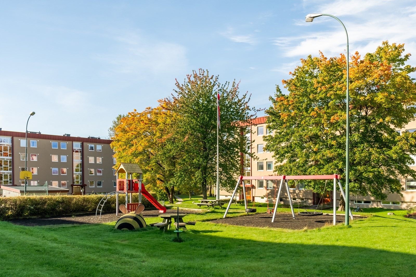 Fellestomten er pent opparbeidet med gressplener, variert vegetasjon, sittegrupper og lekeapparater samt asfalterte gang- og stikkveier. Galleribilde