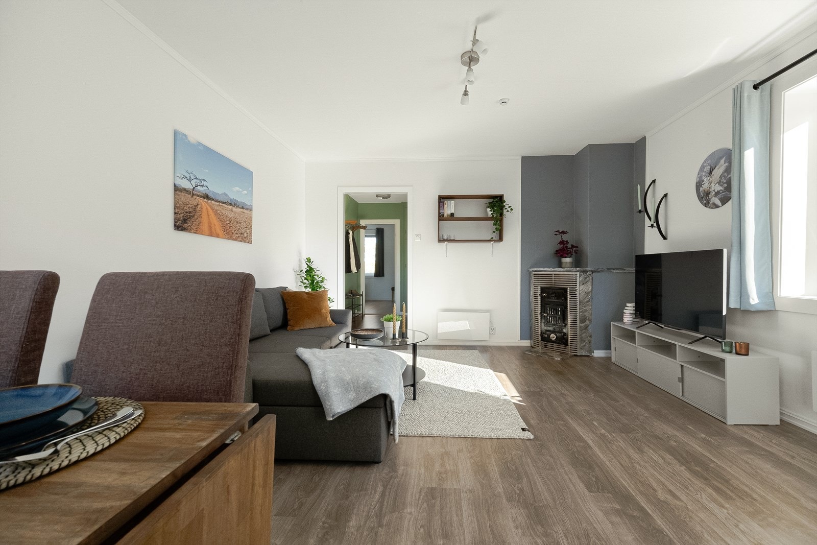 Stuen har pene overflater med laminatgulv og lysmalte, tapetserte veggflater. Galleribilde