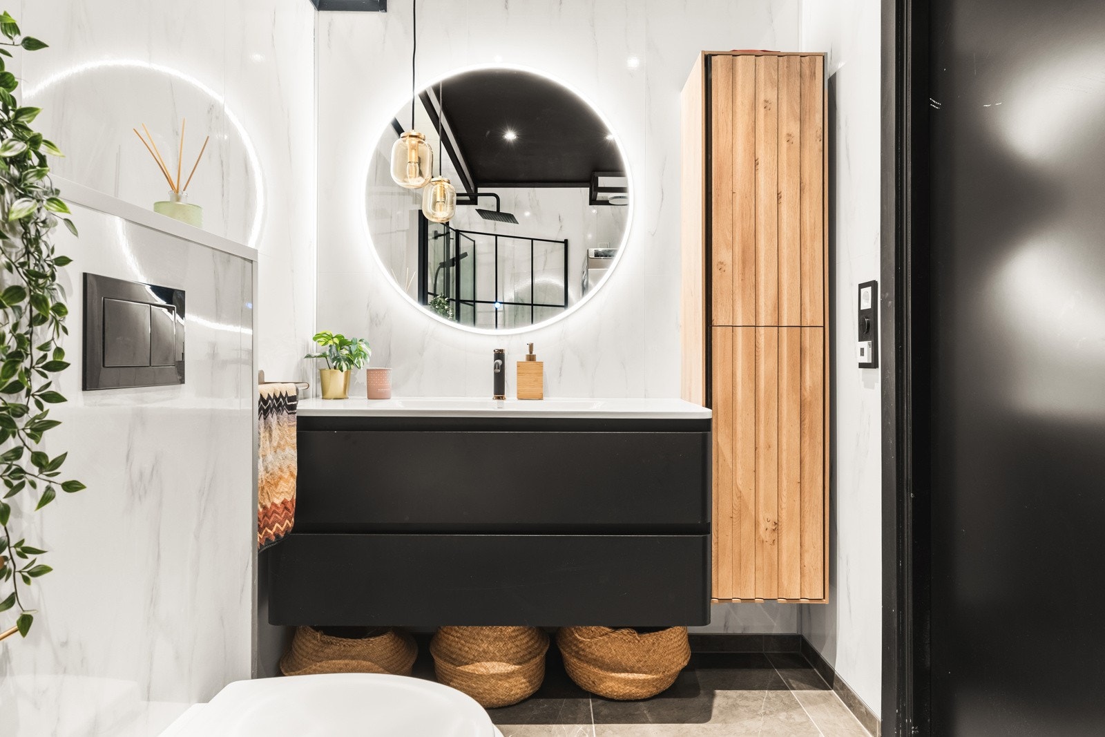 Badet er innredet med vegghengt toalett, dusj med glassvegger, baderomsinnredning og opplegg for vaskemaskin. Galleribilde