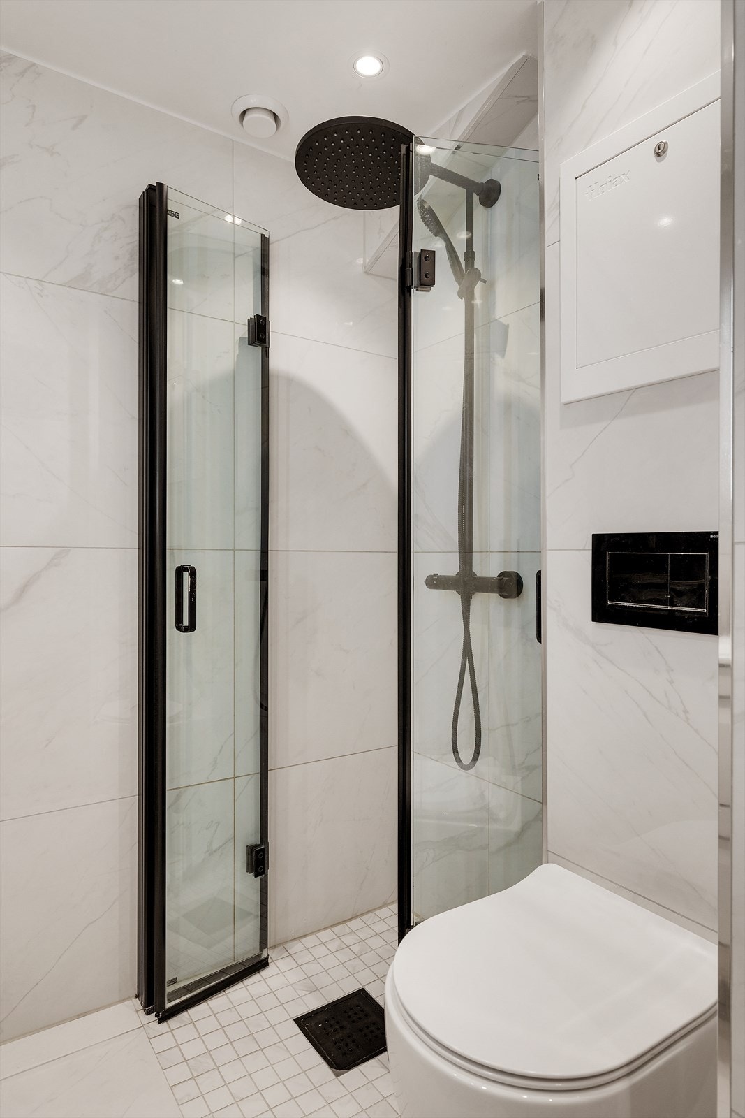 Heldekkende servant nedfeldt i underskap, speil m/integrert lys, veggmontert toalett, dusjhjørne m/glassdører og opplegg for vaskemaskin. Galleribilde