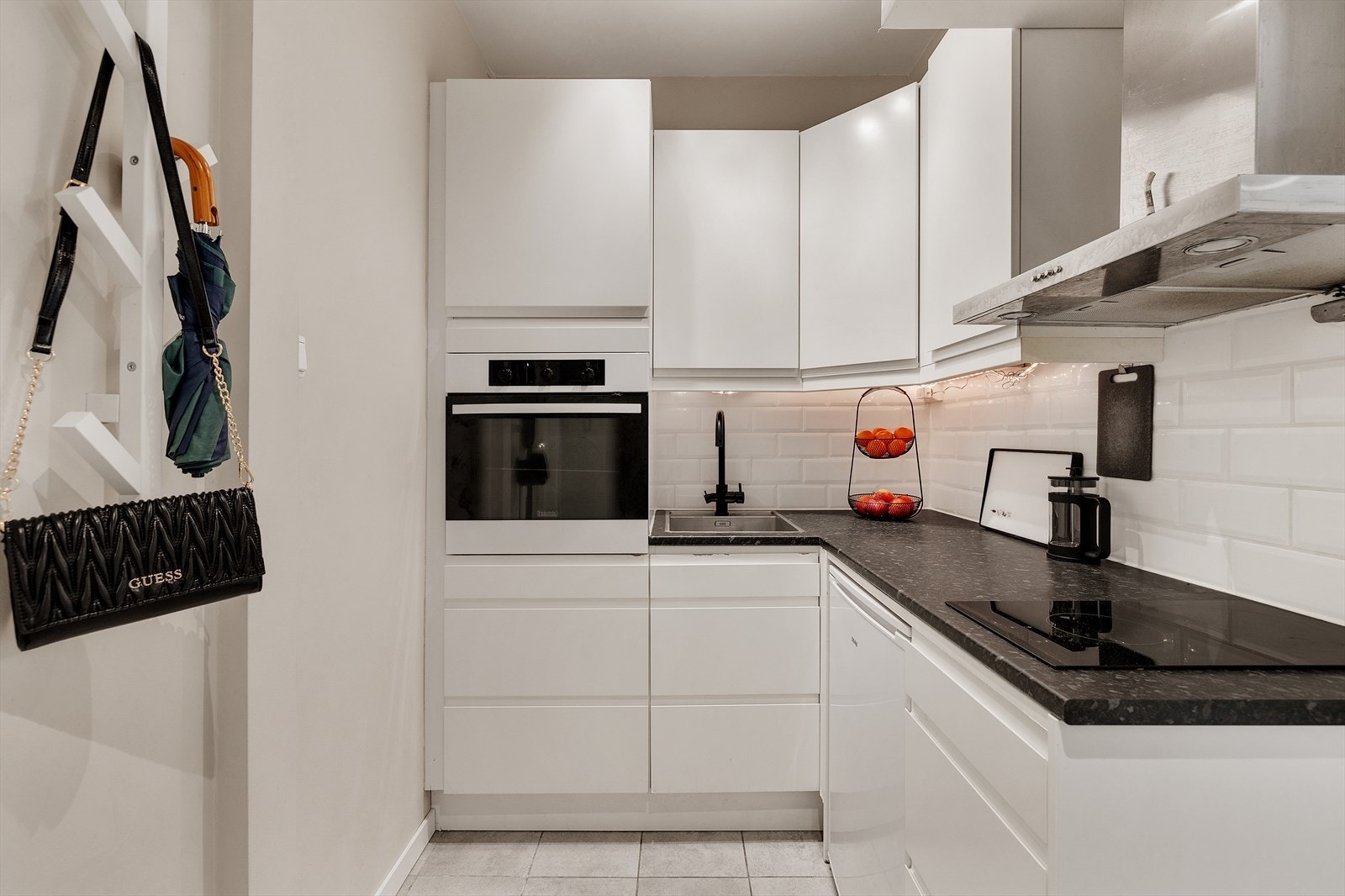 Kjøkkeninnredning med glatte fronter, laminert benkeplate, oppvaskkum, ventilator, fliser over benk og opplegg til oppvaskmaskin. Kjøkkenet er fra 2012. Galleribilde