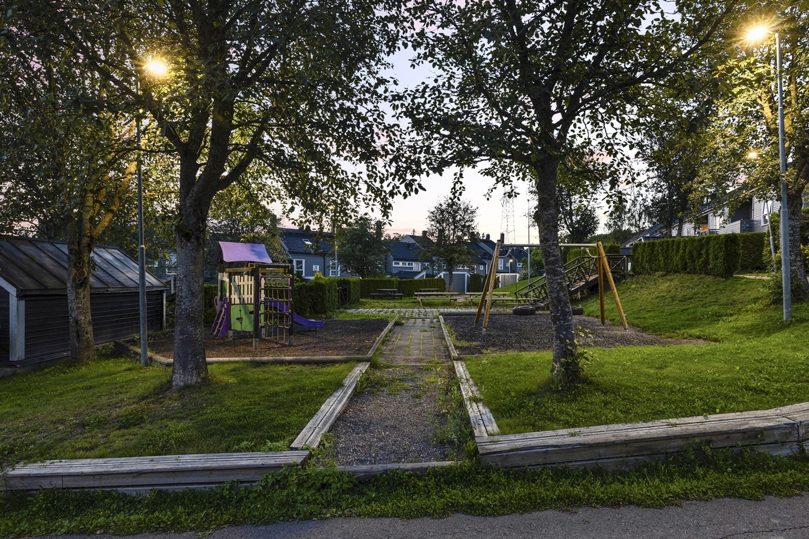 Her er det flere lekeplasser i umiddelbar nærhet, og gode grøntarealer, fin beplantning og store trær som gir grønn, frodig idyll på sommerstid. Galleribilde