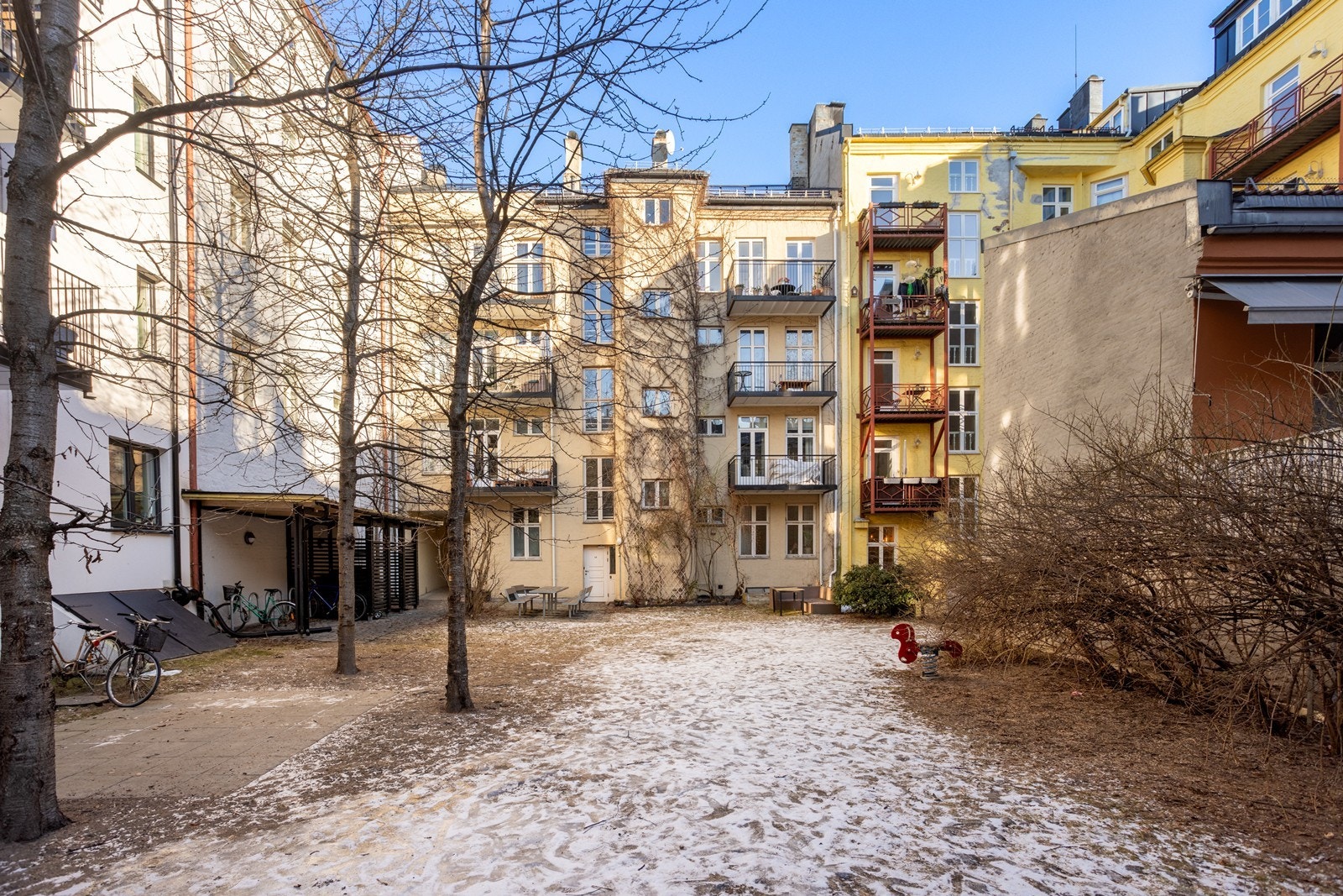 Denne bakhagen er en grønn oase på sommerhalvåret. Det er brosteinsbelagte partier, sykkelskur og sittegrupper. Galleribilde
