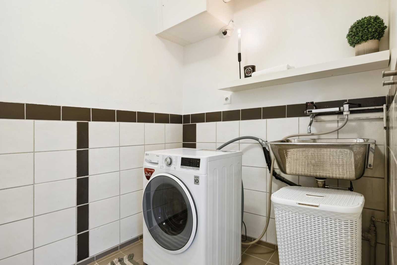 Vaskerom med opplegg for vaskemaskin og varmtvannsbereder i hjørne. Galleribilde