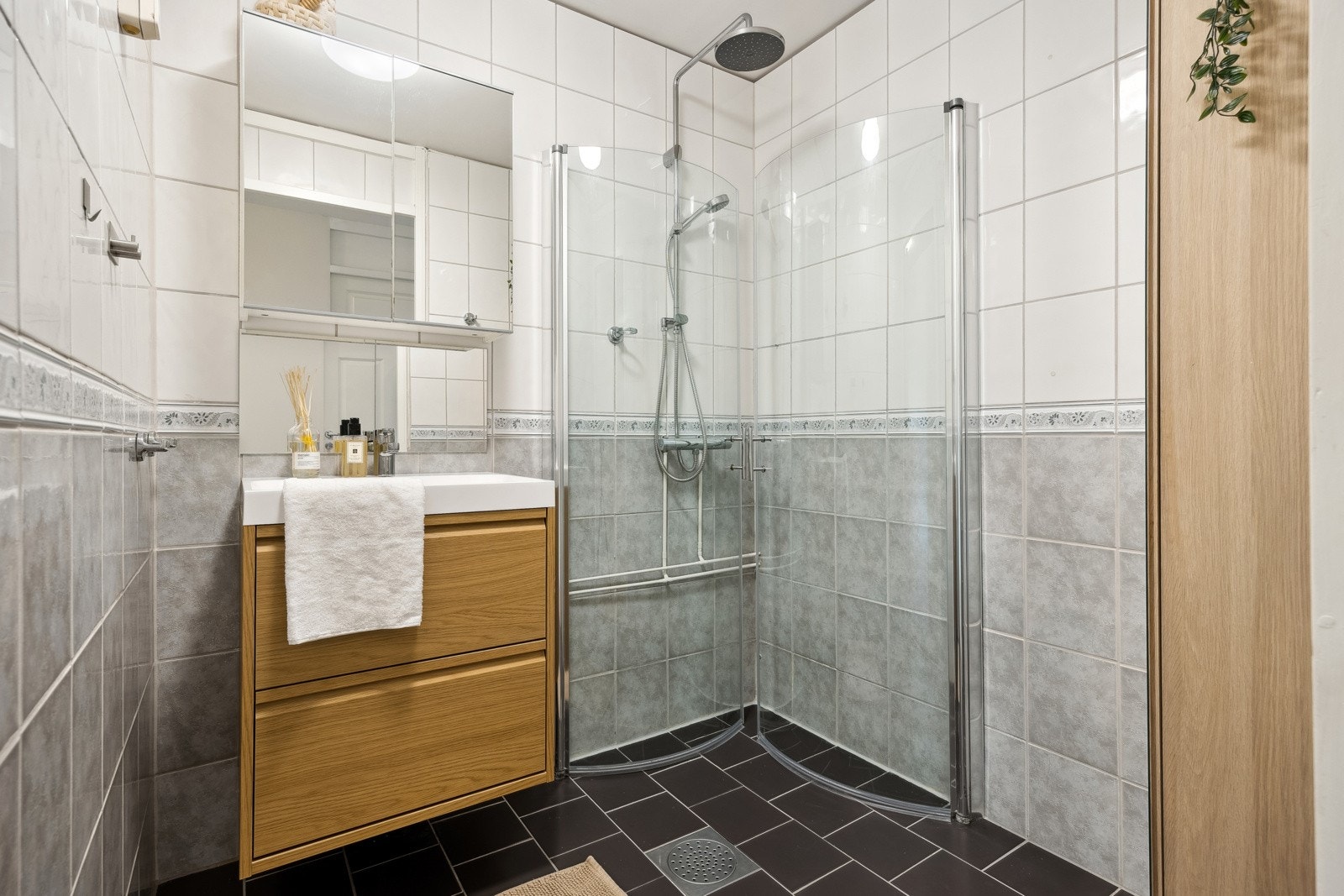 Badet har flislagt gulv med gulvvarme, vegghengt sevrantinnredning og ovenpåliggende servant med armatur. Galleribilde