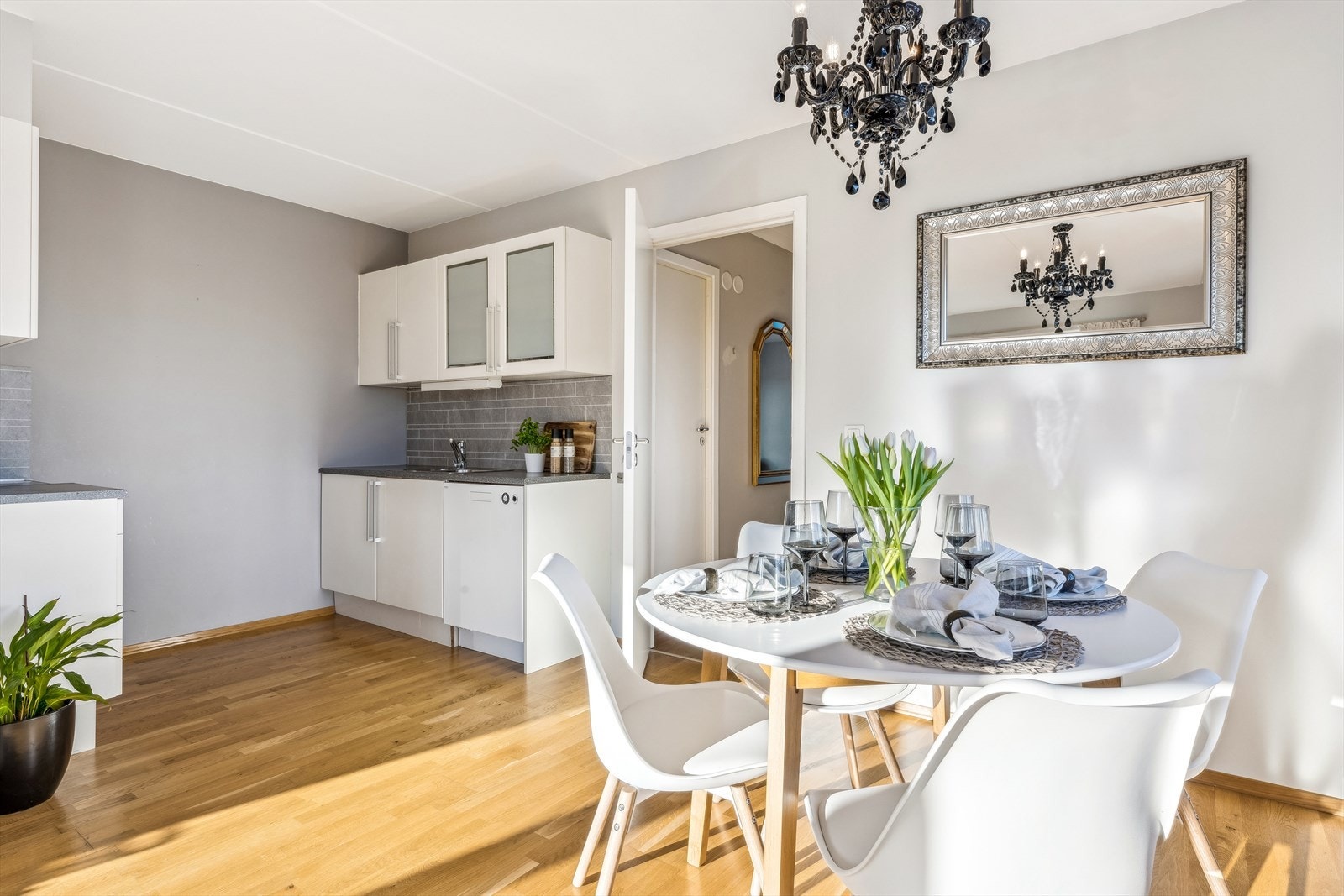 Kjøkkeninnredningen har hvite fronter som gir et rent og moderne uttrykk, mens håndtakene i stål tilfører et elegant og tidløst preg. Galleribilde