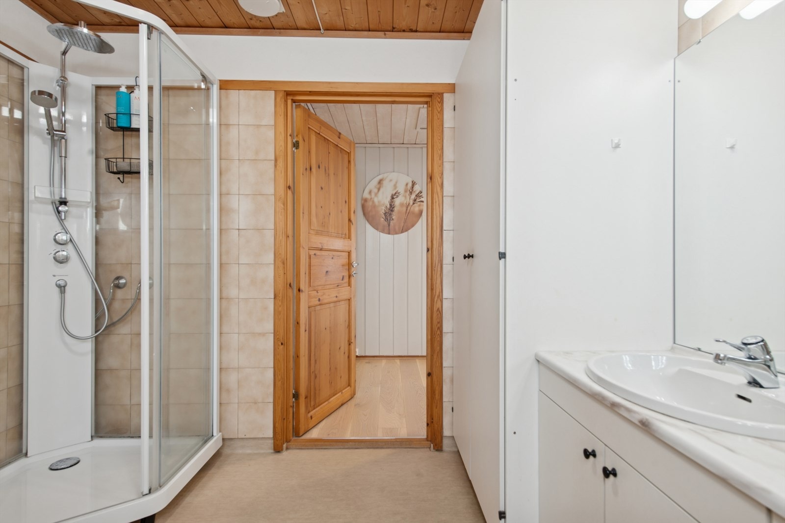 Badet er utstyrt med dusjkabinett, badekar, samt stor baderomsinnredning med servant. Galleribilde