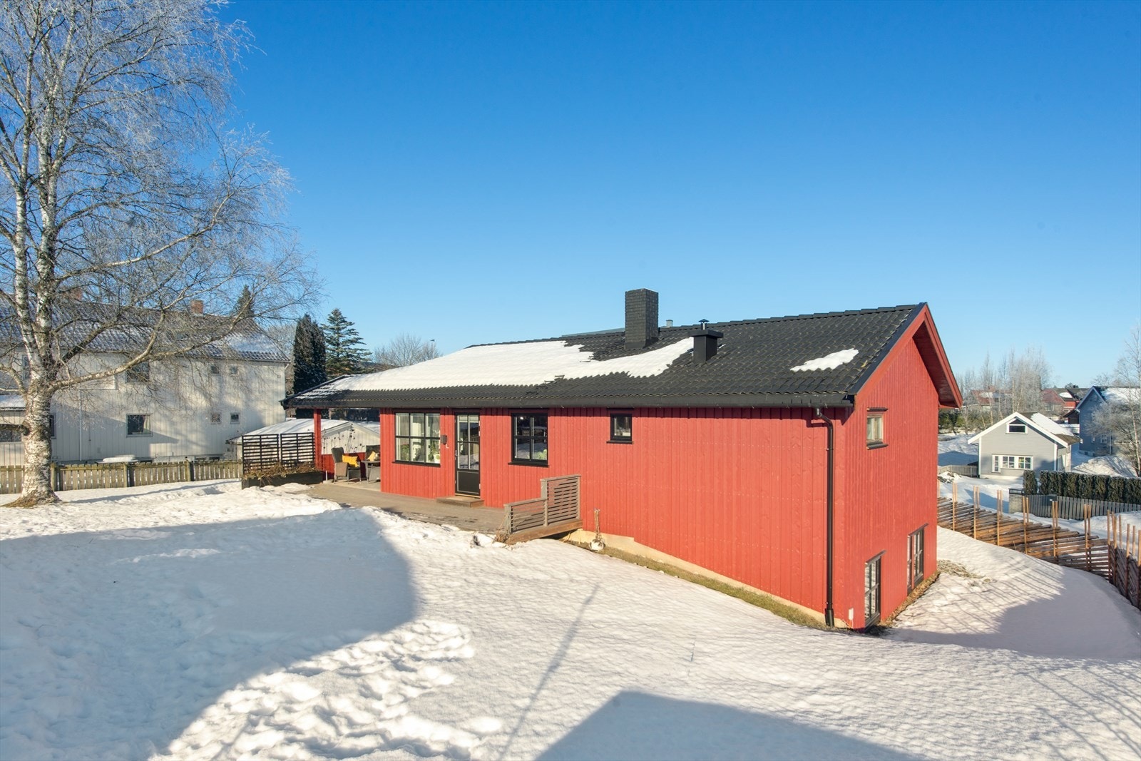 Utgang fra stuen til en stor, solrik terrasse med hagestue som er vestvendt. Galleribilde