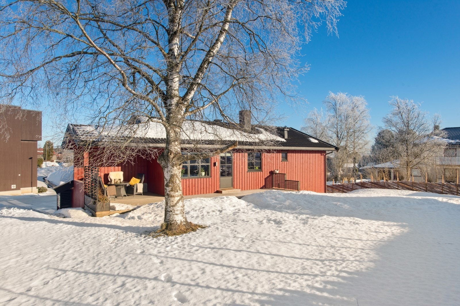 Tomten er lett hellende og pent opparbeidet med gressplen, prydbusker, tre, diverse beplantning og asfaltert gårdsplass. Galleribilde
