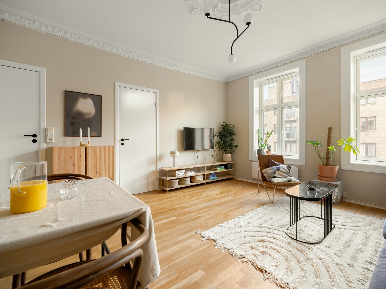 Tilbake i stuen som er selve hjertet i leiligheten, med store generøse vindusflater. Galleribilde