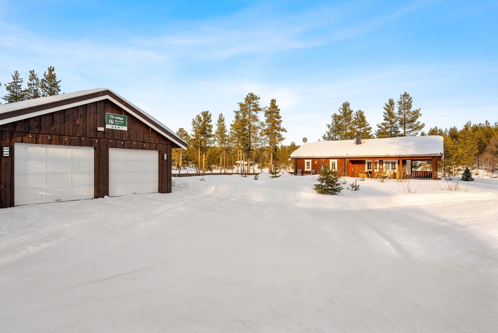 Bilene parkeres i en dobbelgarasje med elbillader og på en stor, gruslagt gårdsplass. Galleribilde