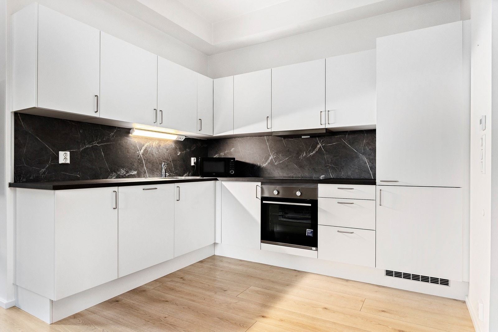 Det er godt med skapplass til oppbevaring. Det er integrert plate topp med induction, stekeovn, kjøl/fryseskap og oppvaskmaskin. Galleribilde