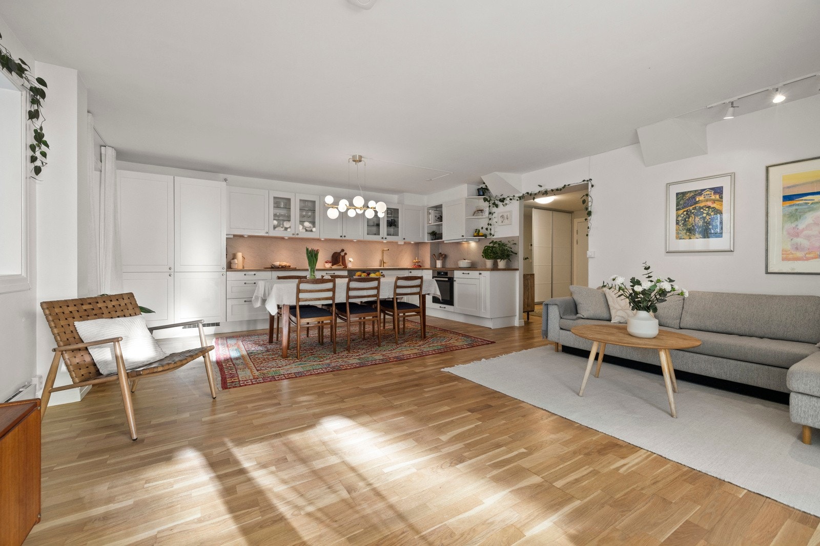 Den åpne løsningen gir plass til et romslig spisebord, noe som skaper en sosial og hyggelig atmosfære - perfekt for gode måltider og samvær med venner og familie. Galleribilde