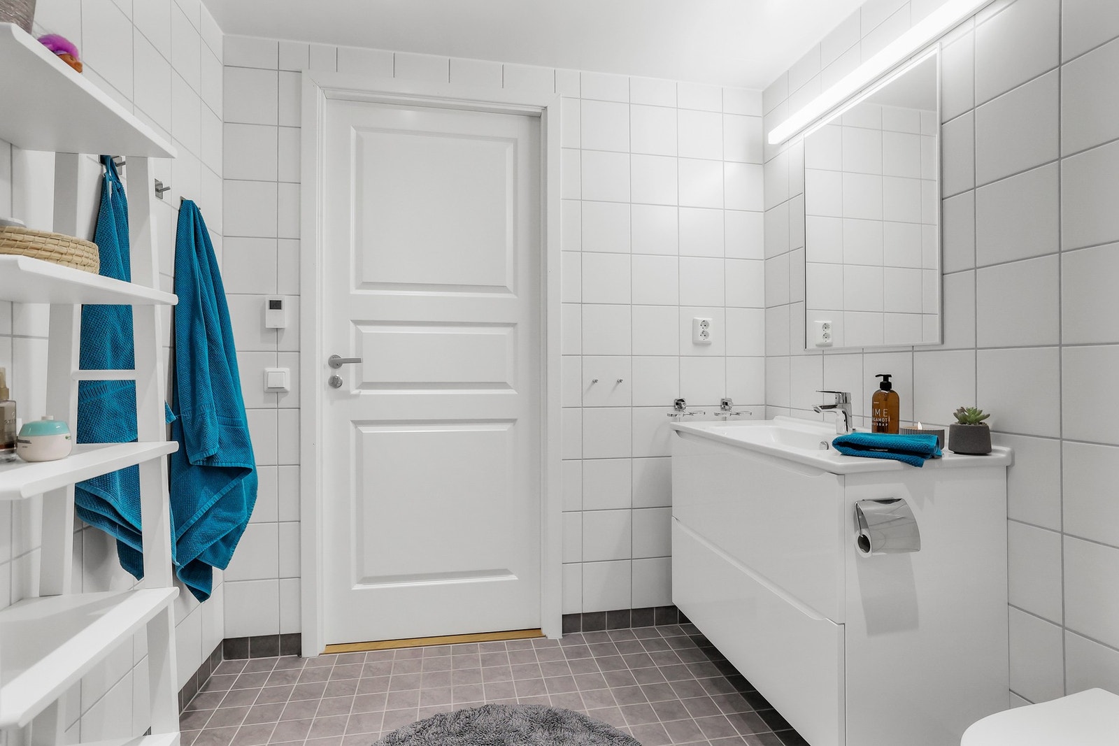 Hovedbadet er stort med lyse fliser, serantskap med speil, vegghengt wc og innfellbar dusjnisje. Galleribilde