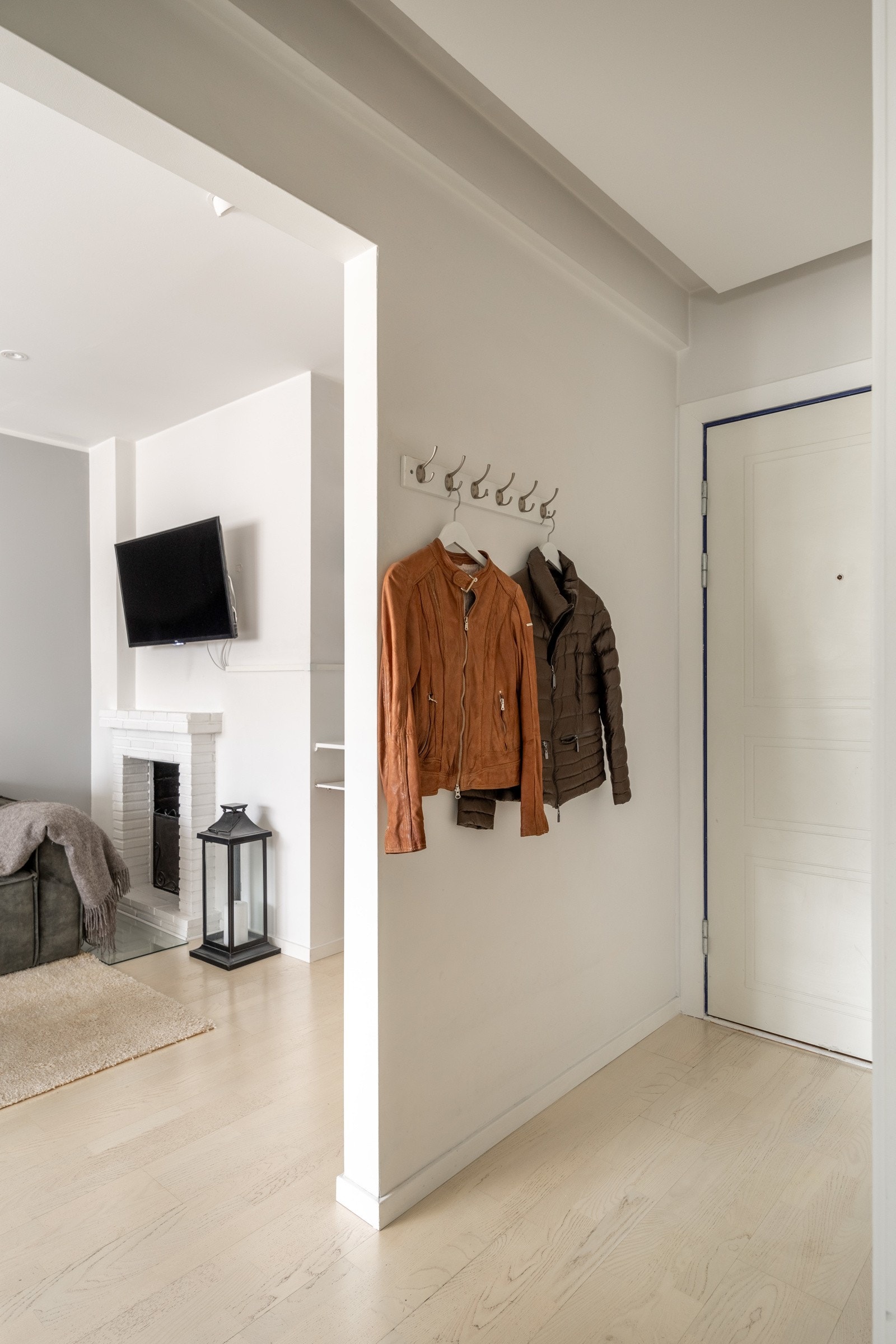 Lys entré med plass til oppheng av yttertøy og oppbevaring av sko. Galleribilde