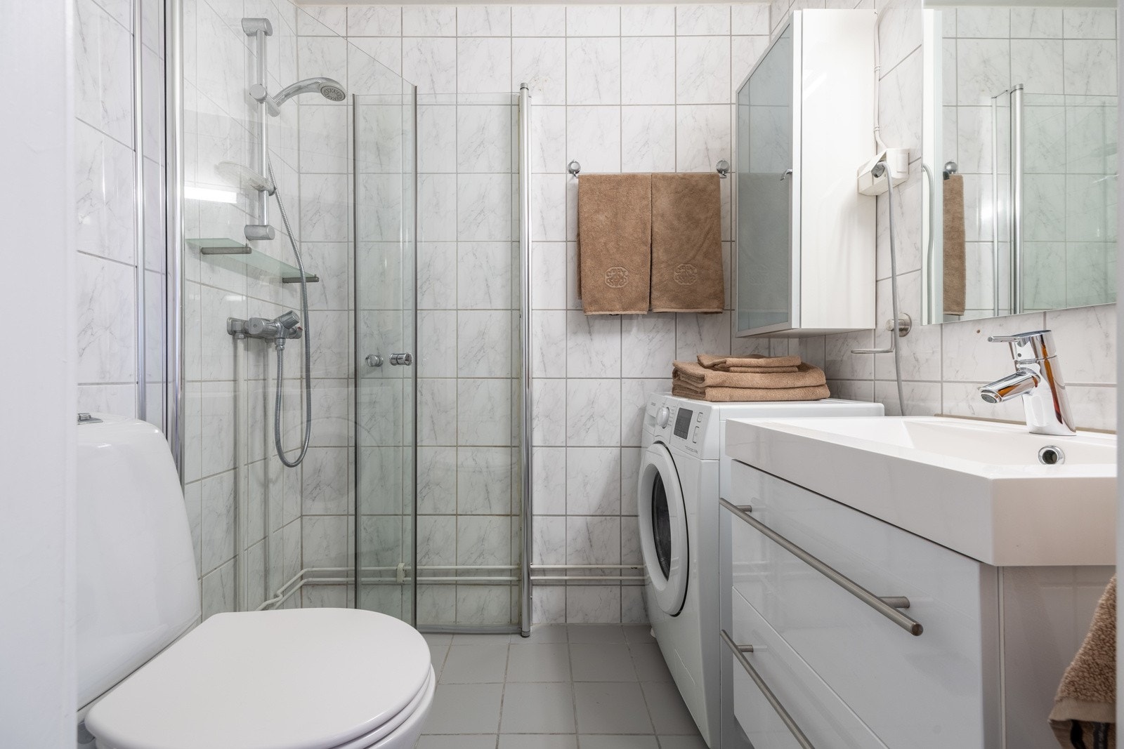 Baderom med flislagt gulv med varme. Badet har opplegg for vaskemaskin. Galleribilde