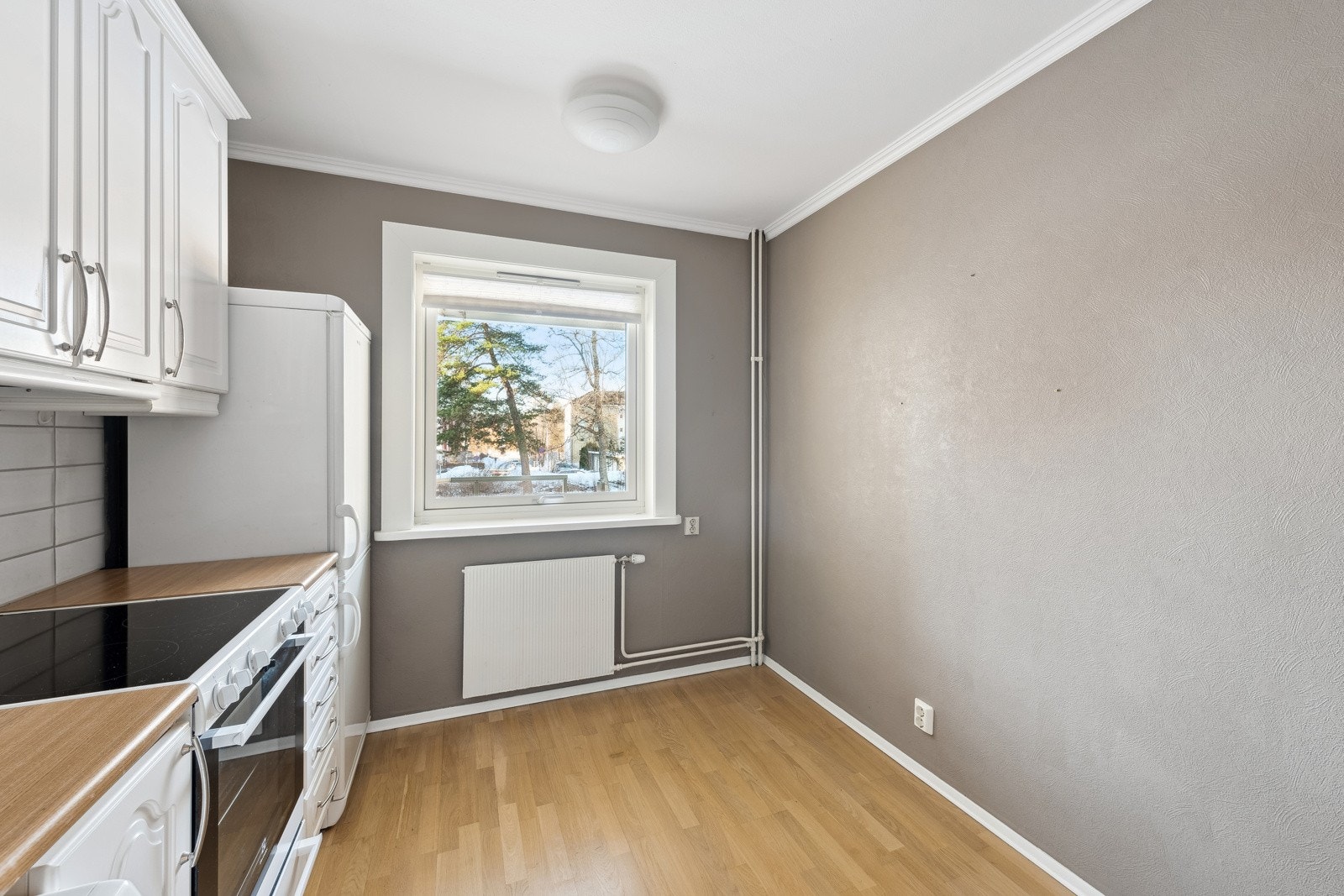 Kjøkken med benkeplate i laminat med fliser over benk. Galleribilde