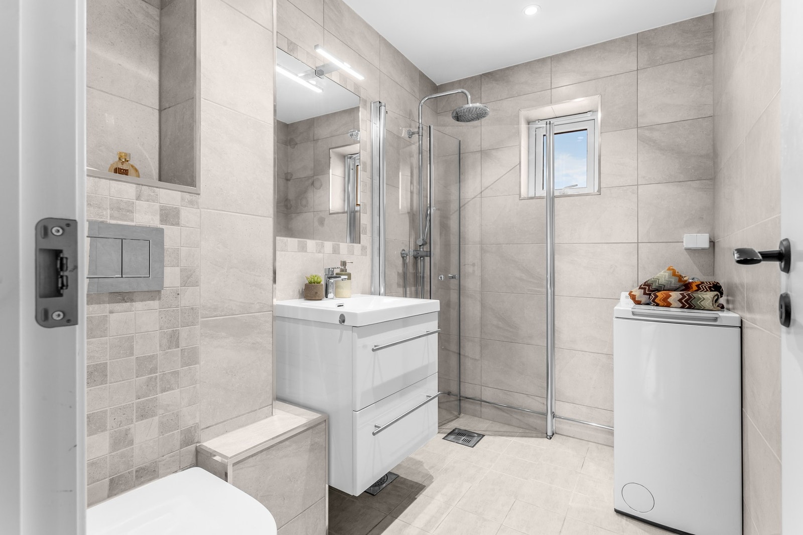 Delikat, flislagt baderom fra 2017 med gulvvarme. Servantskap med høyglans fronter og heldekkende servant. Galleribilde