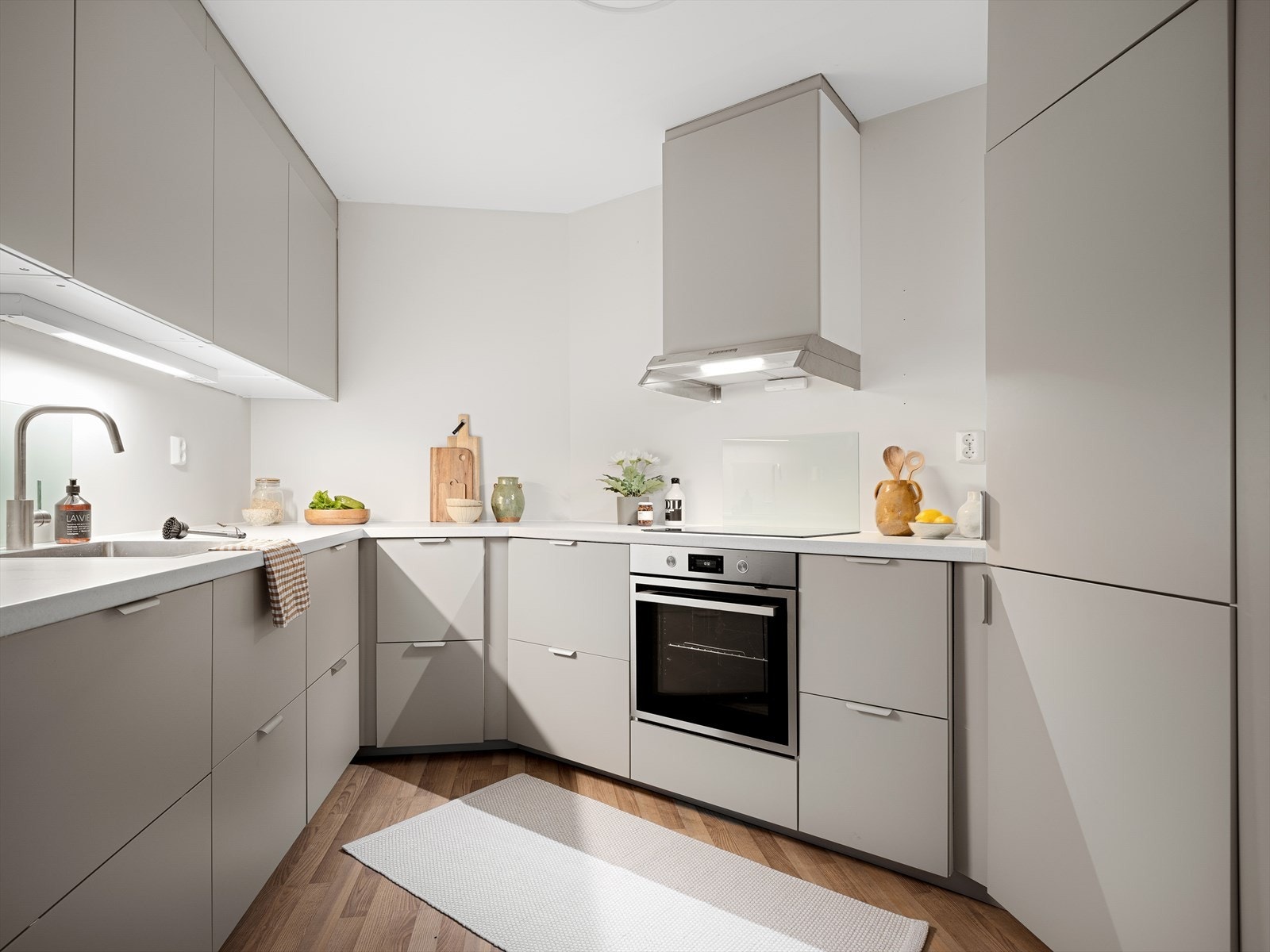 Stilren kjøkkeninnredning fra 2024 med grå, mattlakkerte, glatte fronter. Galleribilde