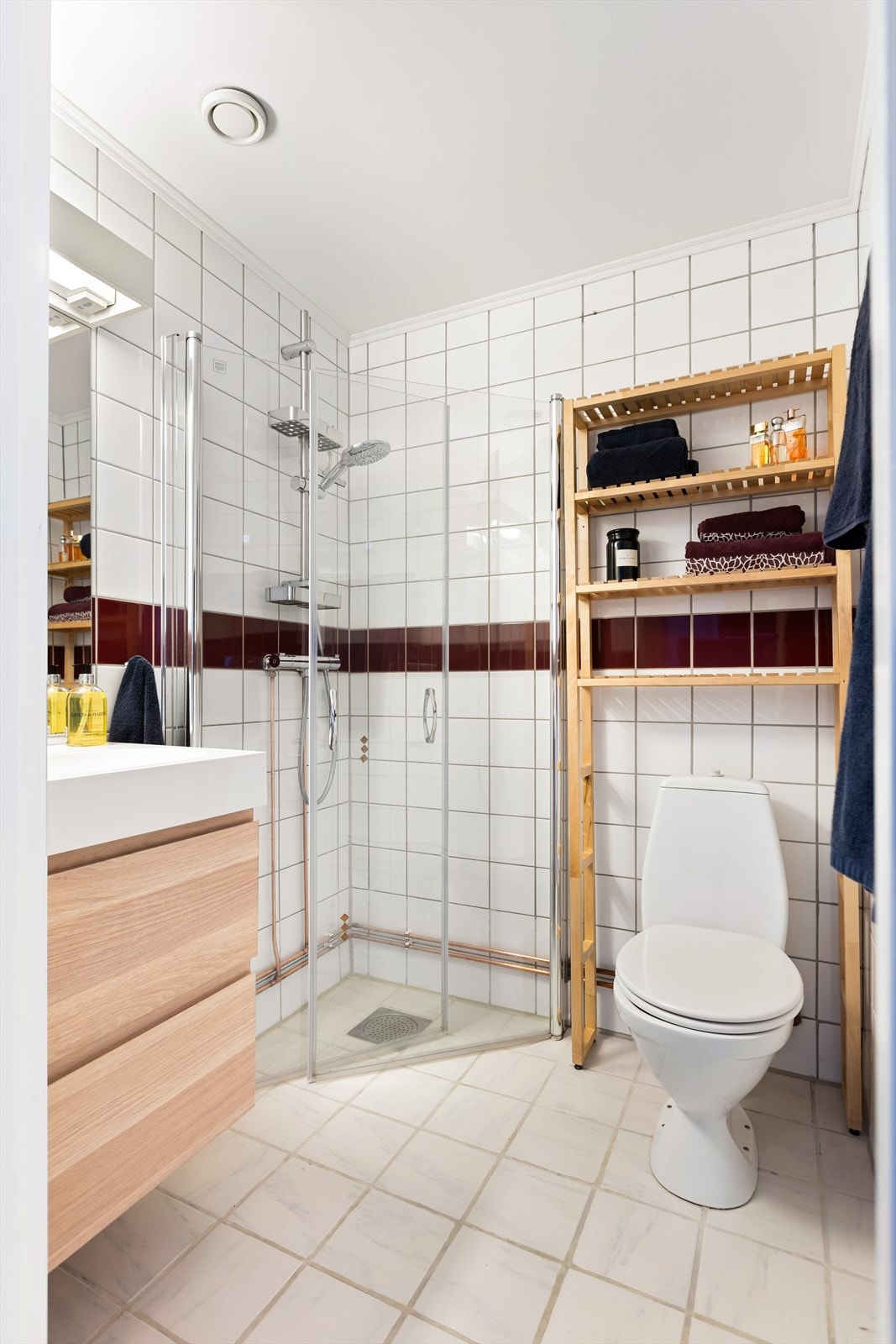 Badet er innredet med toalett, servant med nyere baderomsinnredning og dusj med innfellbare dører av glass. Galleribilde